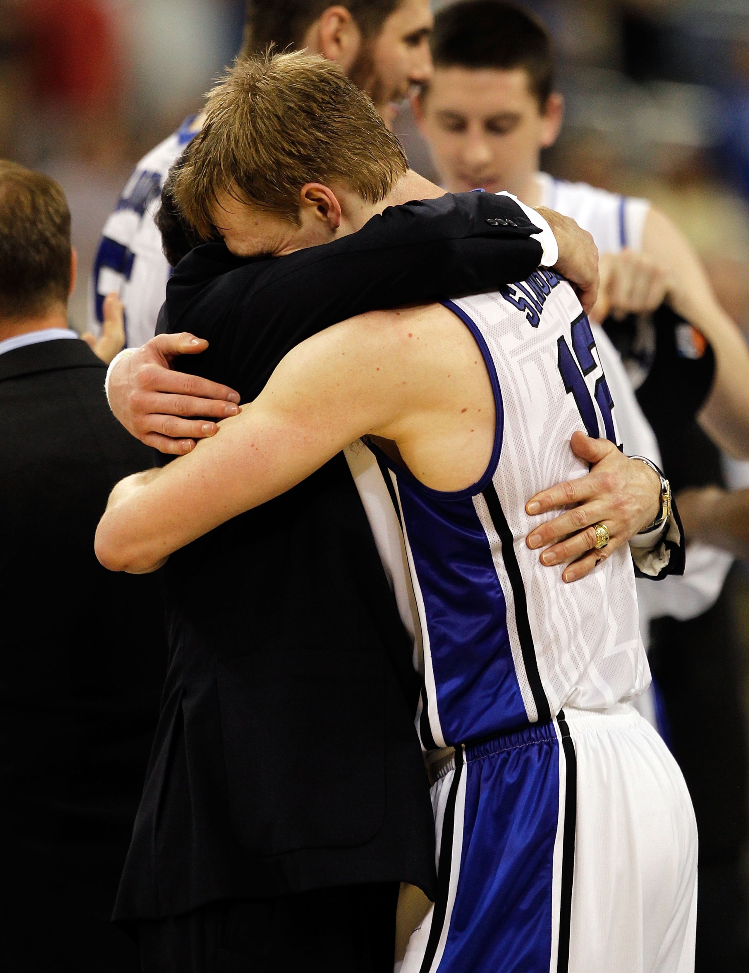 HOUSTON - MARCH 28: Kyle Singler #12 of the Duke Blue Devils hugs head coach Mike Krzyzewski following a win over the Baylor Bears during the south regional final of the 2010 NCAA men's basketball tournament at Reliant Stadium on March 28, 2010 in Houston