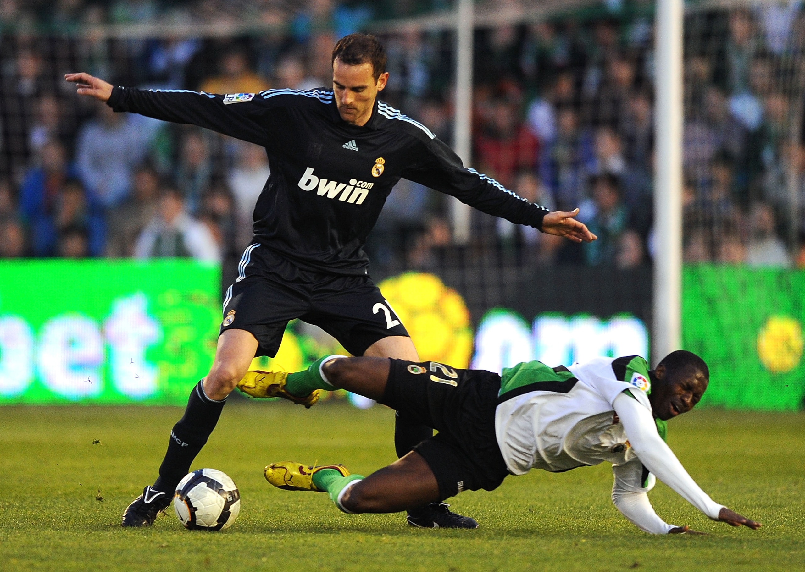 SANTANDER, SPAIN - APRIL 04: Cristoph Metzelder (L)  of Real Madrid tackles Papakouly Diop of Racing Santander during the La Liga match between Racing Santander and Real Madrid at El Sardinero stadium on April 4, 2010 in Santander, Spain.  (Photo by Denis