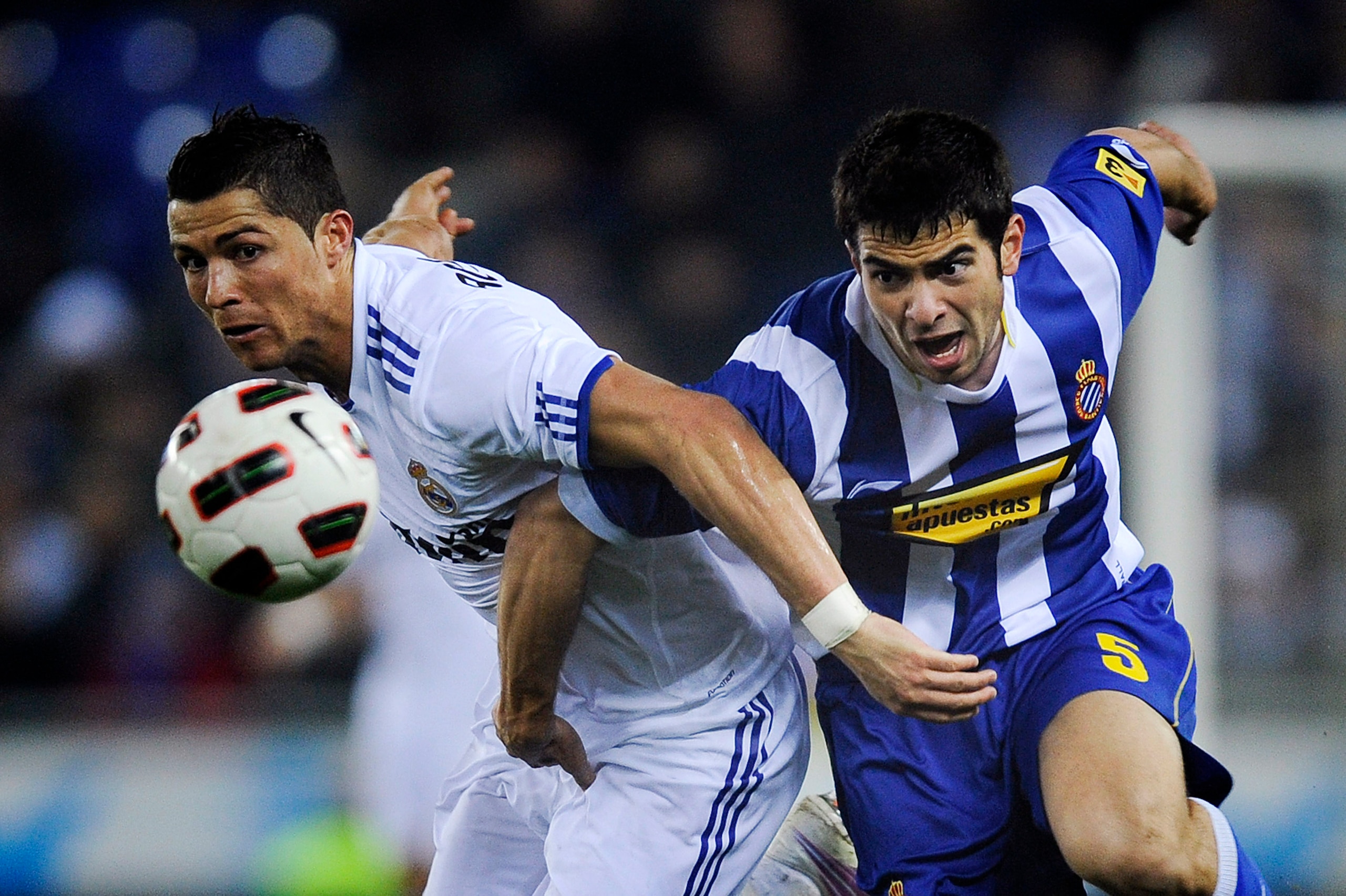 BARCELONA, SPAIN - FEBRUARY 13:  Cristiano Ronaldo of Real Madrid (L) duels for the ball against Jordi Amat of RCD Espanyol during La Liga match between RCD Espanyol and Real Madrid at Estadi Cornella-El Prat on February 13, 2011 in Barcelona, Spain. Real