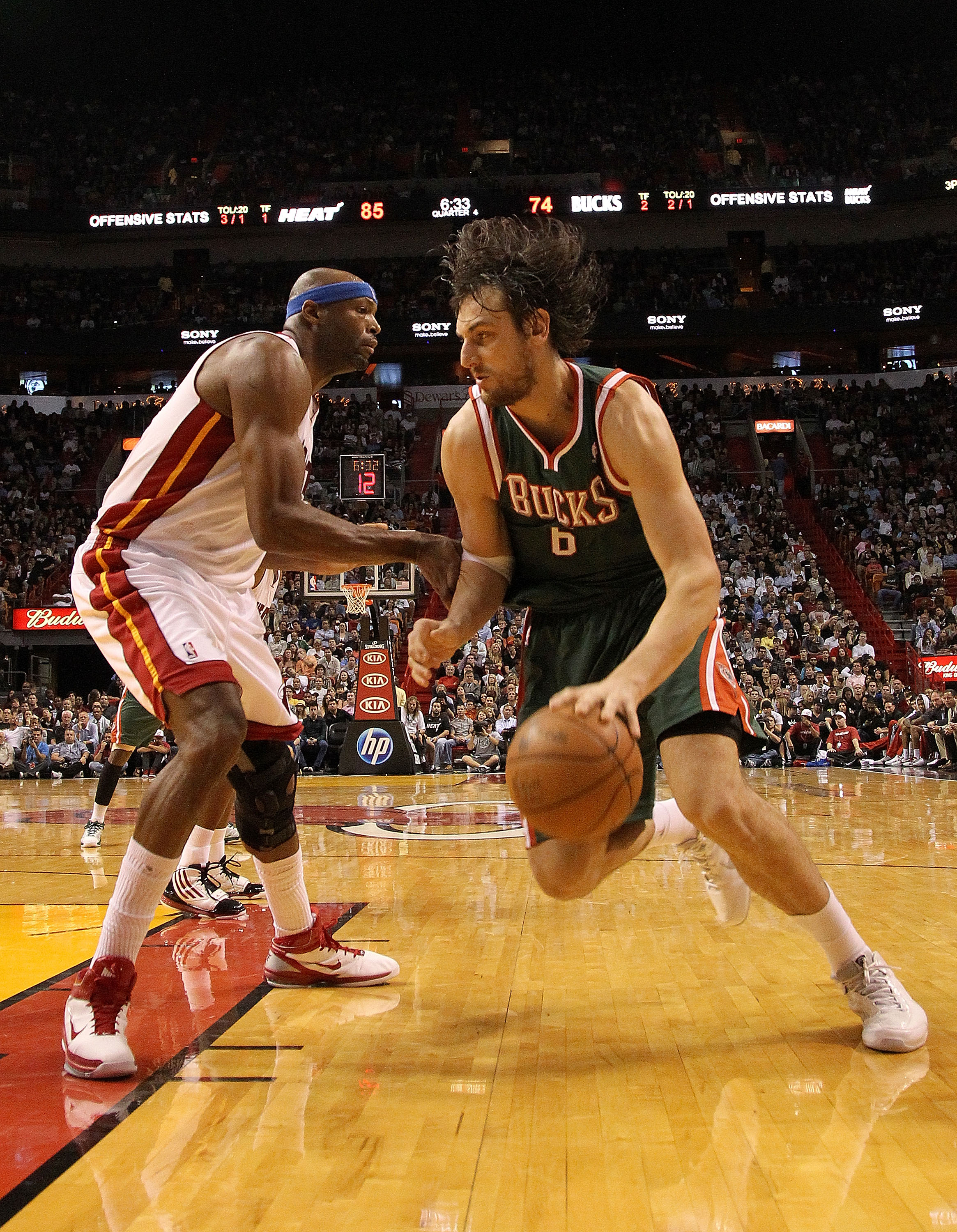 MIAMI, FL - JANUARY 04:  Andrew Bogut #6 of the Milwaukee Bucks dribbles past Erick Dampier #25 of the Miami Heat during a game at American Airlines Arena on January 4, 2011 in Miami, Florida. NOTE TO USER: User expressly acknowledges and agrees that, by