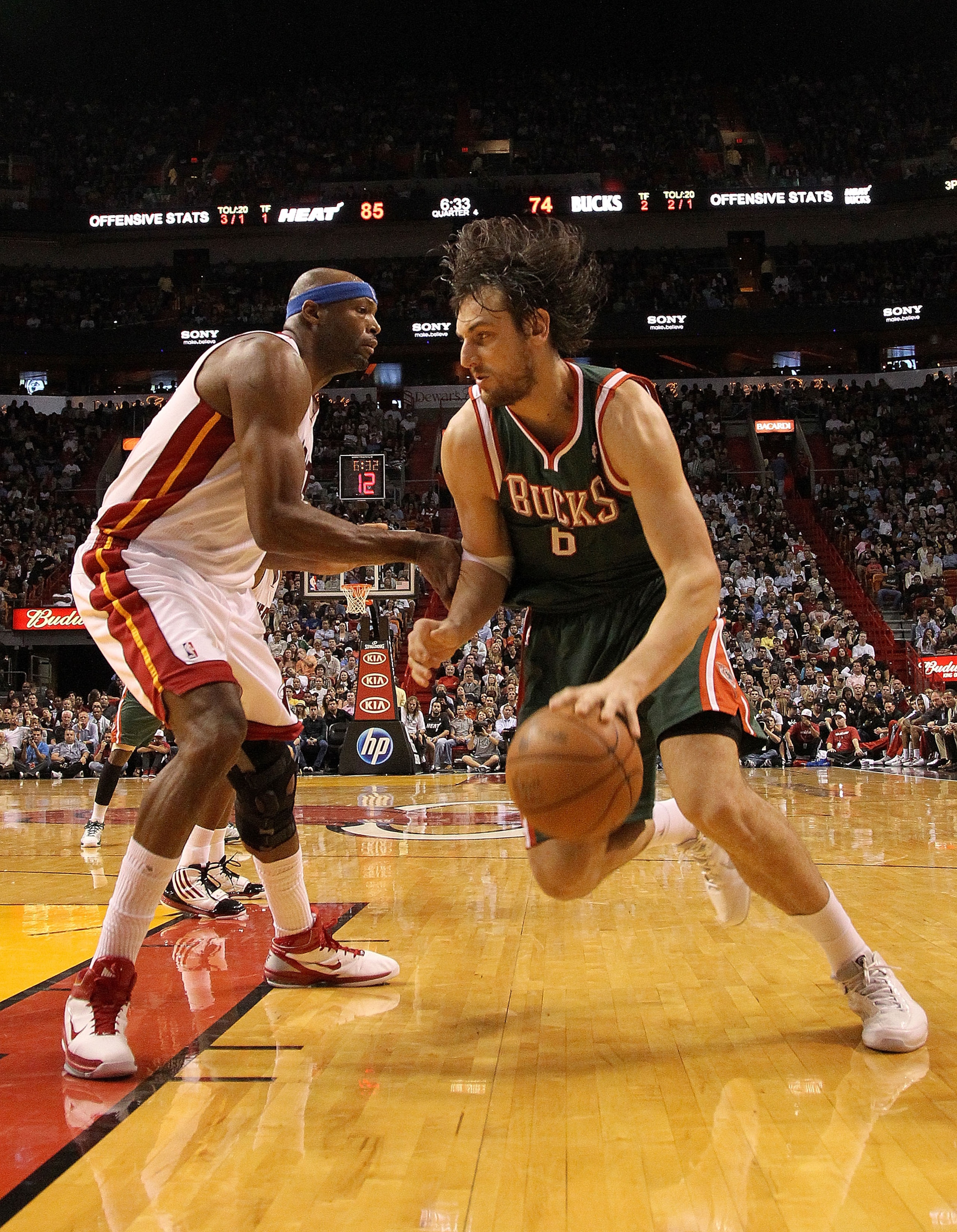 MIAMI, FL - JANUARY 04:  Andrew Bogut #6 of the Milwaukee Bucks dribbles past Erick Dampier #25 of the Miami Heat during a game at American Airlines Arena on January 4, 2011 in Miami, Florida. NOTE TO USER: User expressly acknowledges and agrees that, by