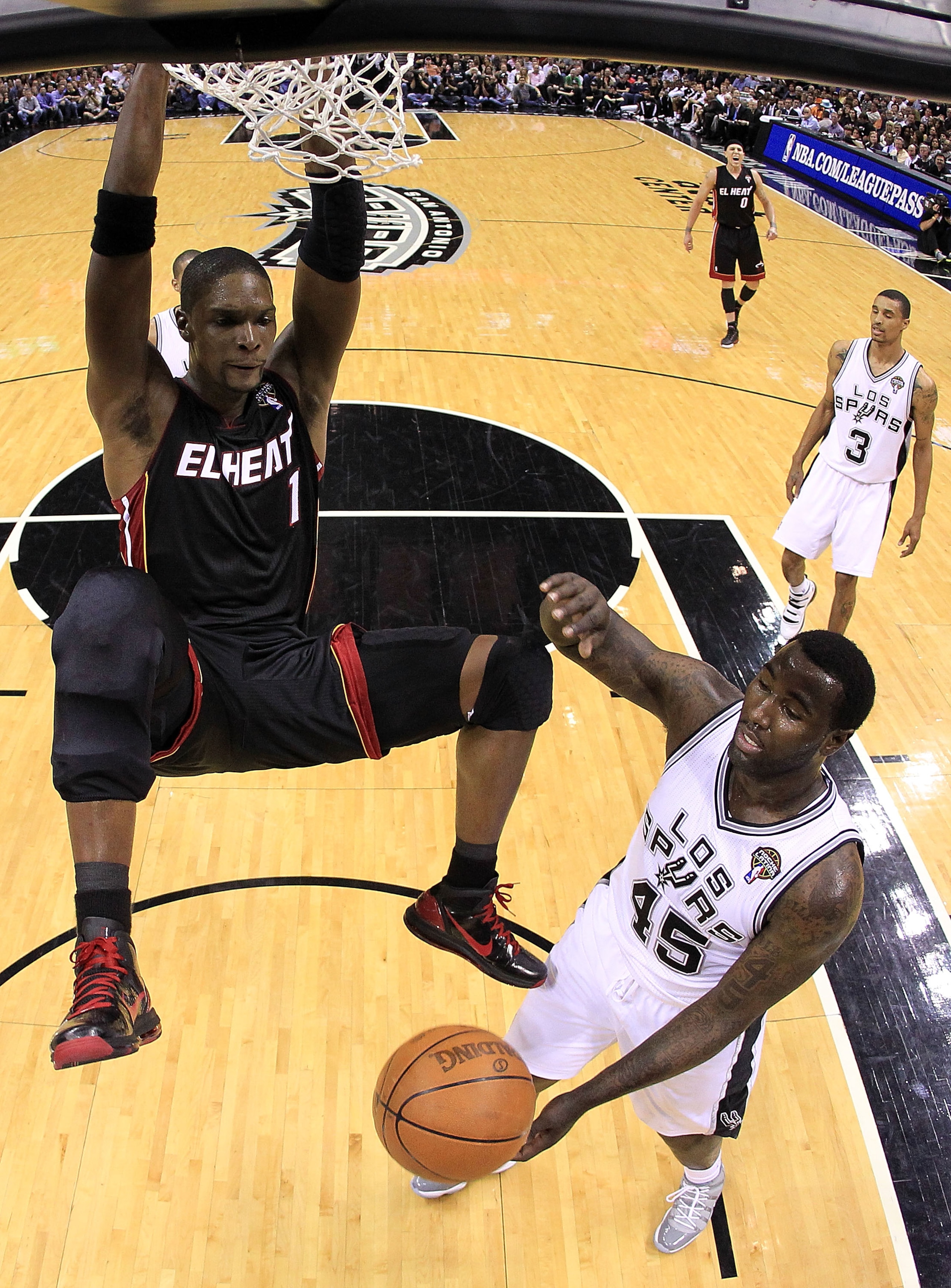 SAN ANTONIO, TX - MARCH 04:  Forward Chris Bosh #1 of the Miami Heat gets the slam dunk against DeJuan Blair #45 of the San Antonio Spurs at AT&T Center on March 4, 2011 in San Antonio, Texas.   NOTE TO USER: User expressly acknowledges and agrees that, b