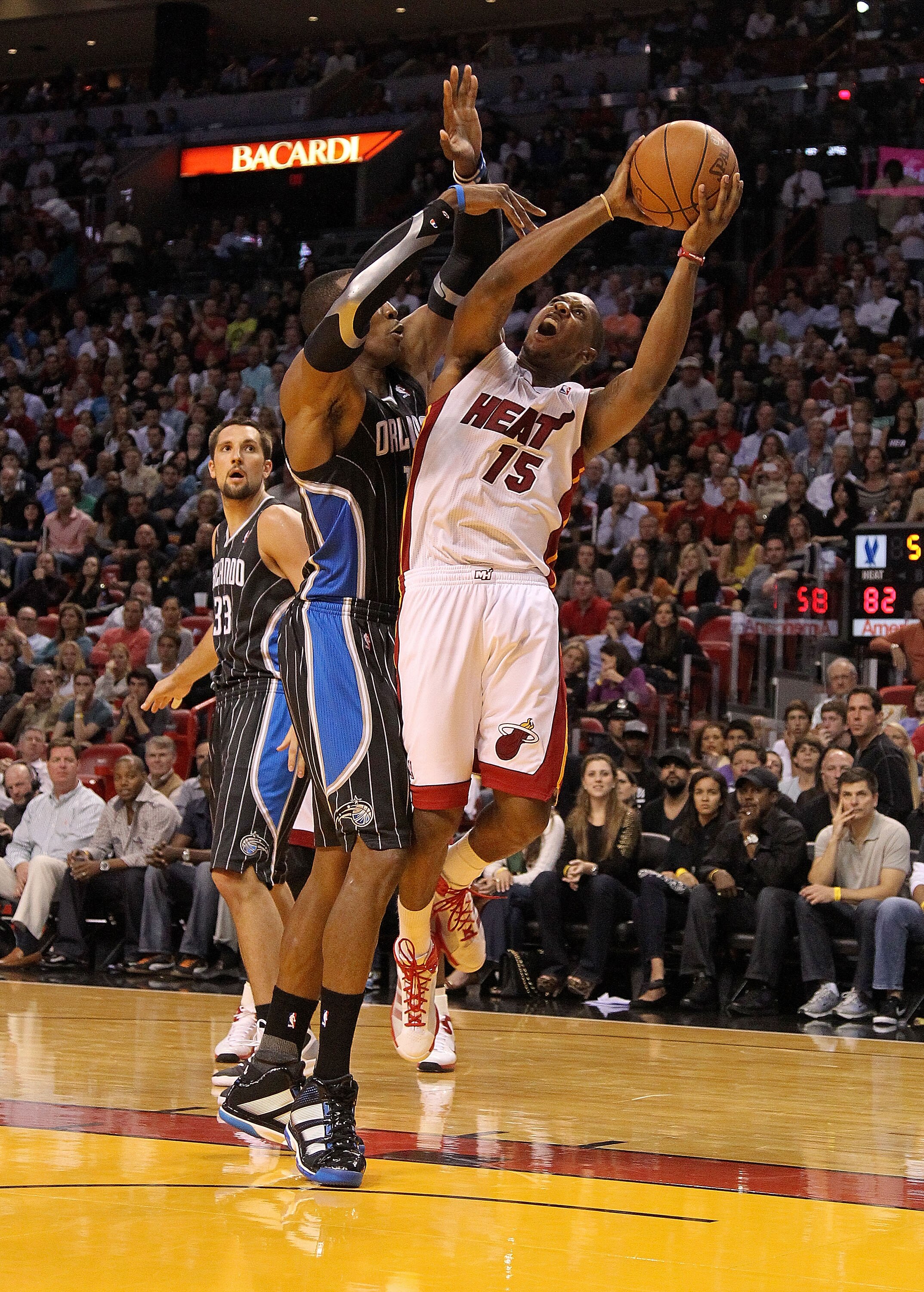 MIAMI, FL - MARCH 03:  Mario Chalmers #15 of the Miami Heat is fouled by Dwight Howard #12 of the Orlando Magic during a game at American Airlines Arena on March 3, 2011 in Miami, Florida. NOTE TO USER: User expressly acknowledges and agrees that, by down