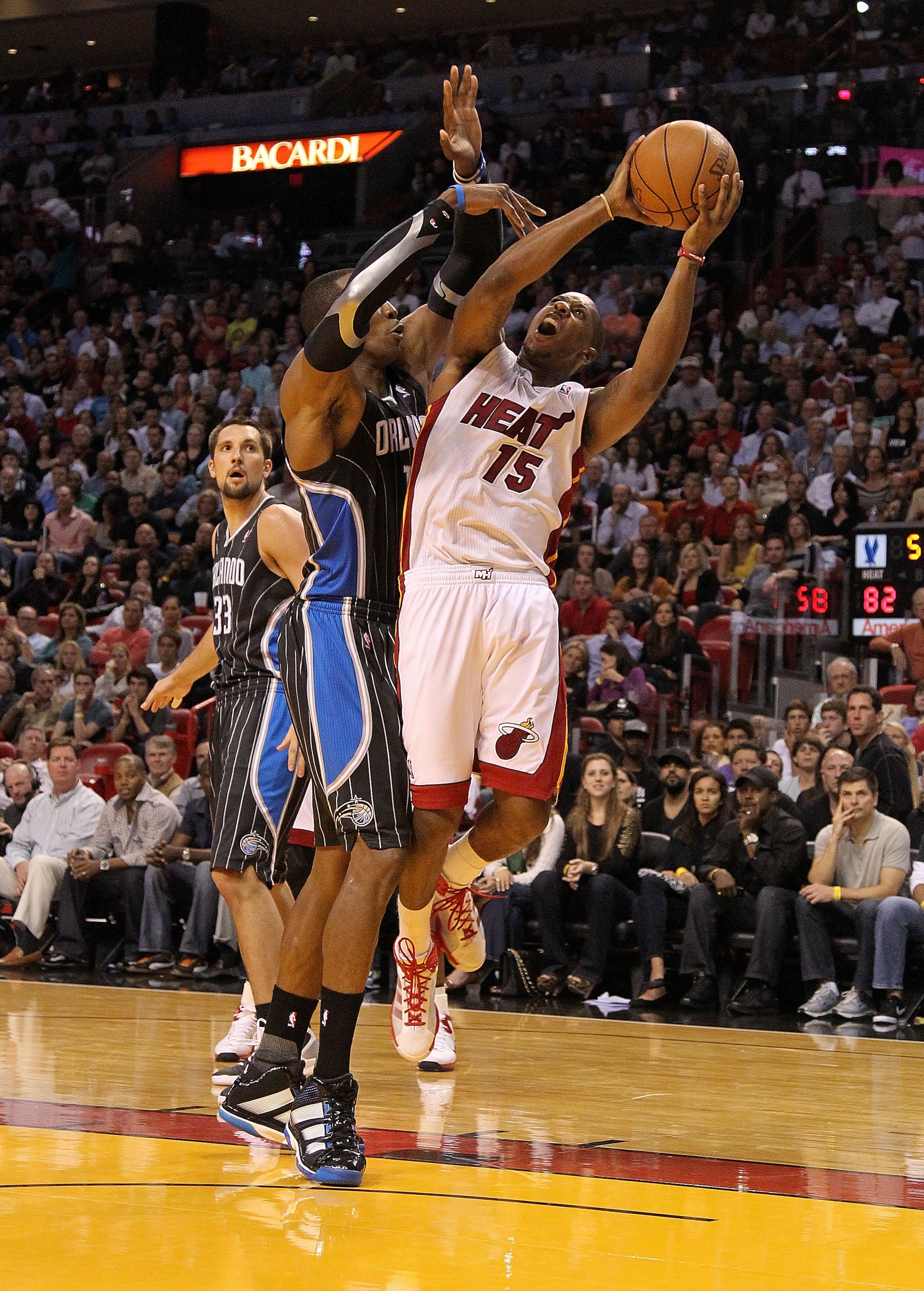 MIAMI, FL - MARCH 03:  Mario Chalmers #15 of the Miami Heat is fouled by Dwight Howard #12 of the Orlando Magic during a game at American Airlines Arena on March 3, 2011 in Miami, Florida. NOTE TO USER: User expressly acknowledges and agrees that, by down