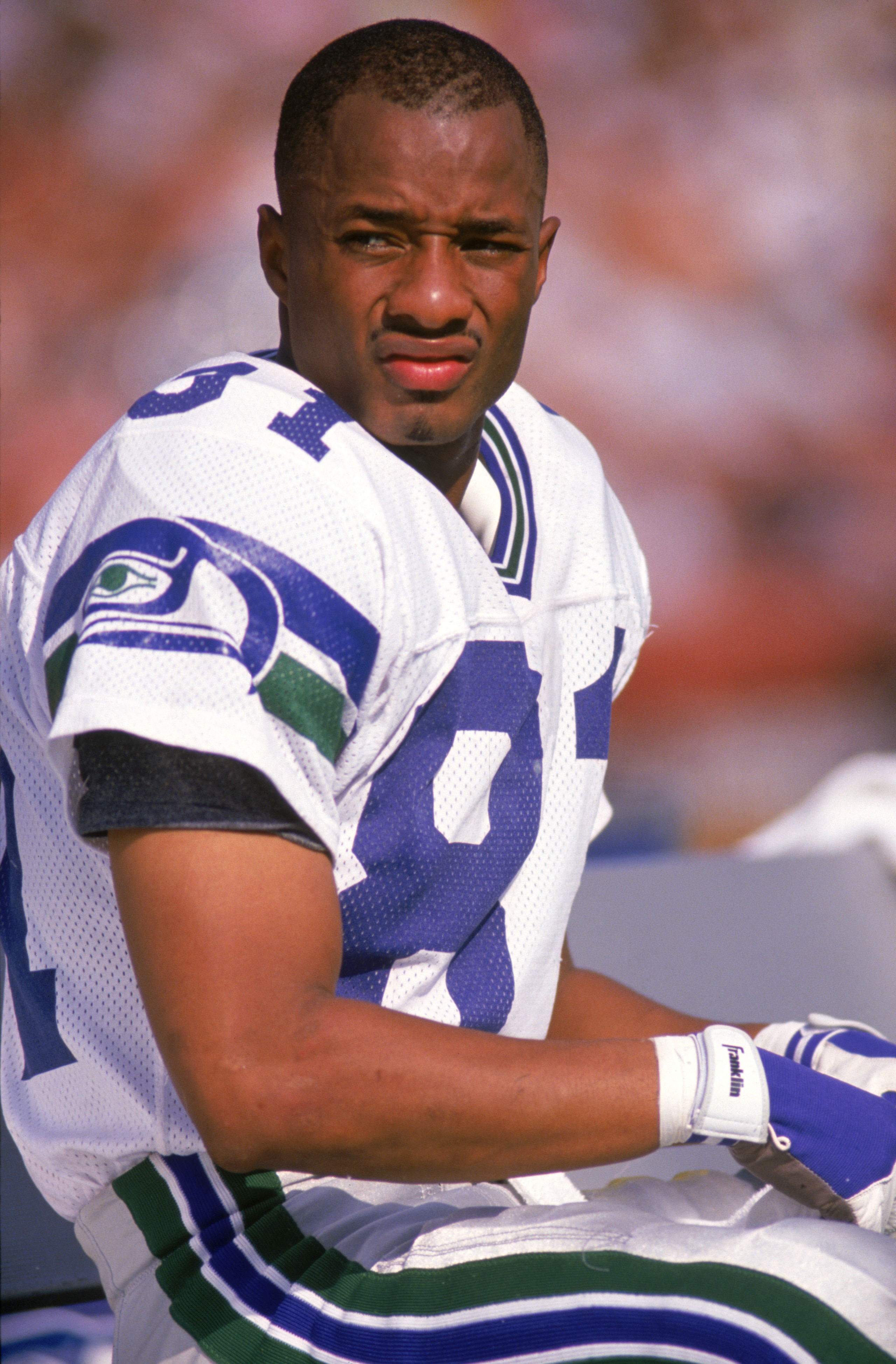 LOS ANGELES - OCTOBER 14:  Wide receiver Tommy Kane #81 of the Seattle Seahawks looks on as he sits on the bench during a game against the Los Angeles Raider at Los Angeles Memorial Coliseum on October 14, 1990 in Los Angeles, California.  The Raiders won