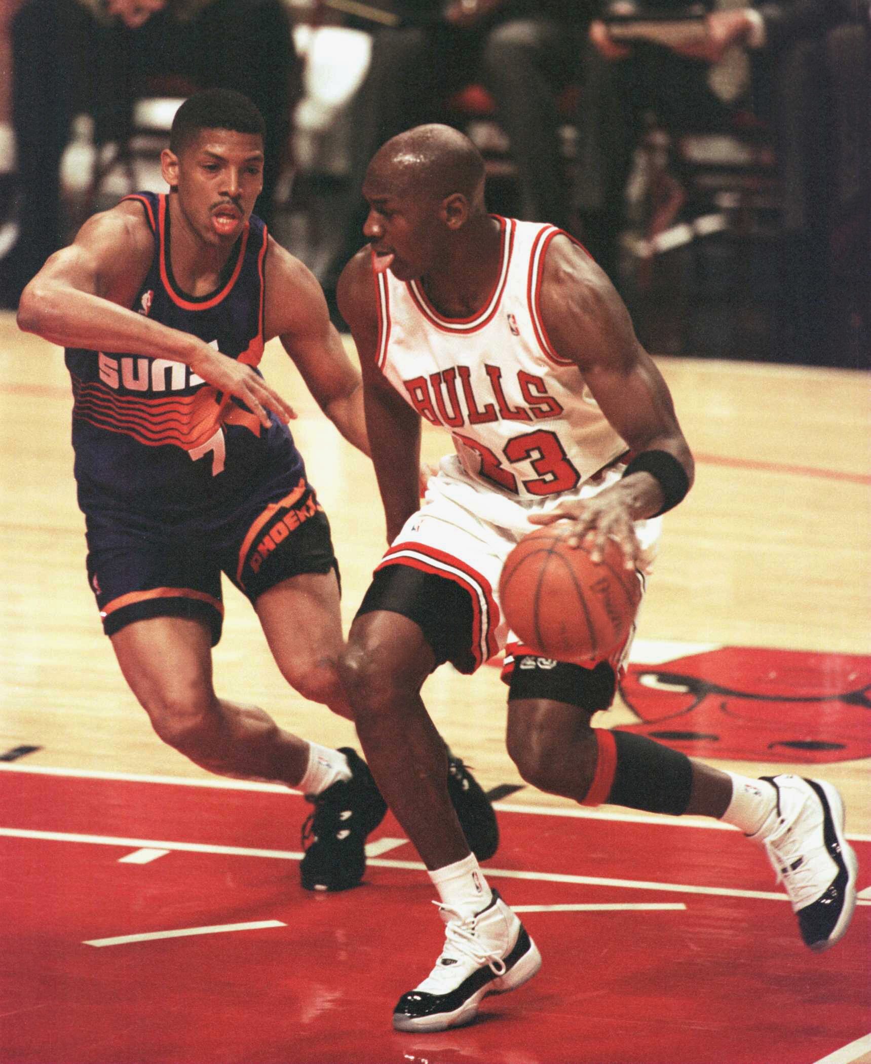 28 Jan 1996:  Forward Michael Jordan of the Chicago Bulls drives the lane past guard Kevin Johnson of the Phoenix Suns during first half action of the game at the United Center in Chicago, Illinois. The Bulls went on to beat the Suns 93-82, extending thei