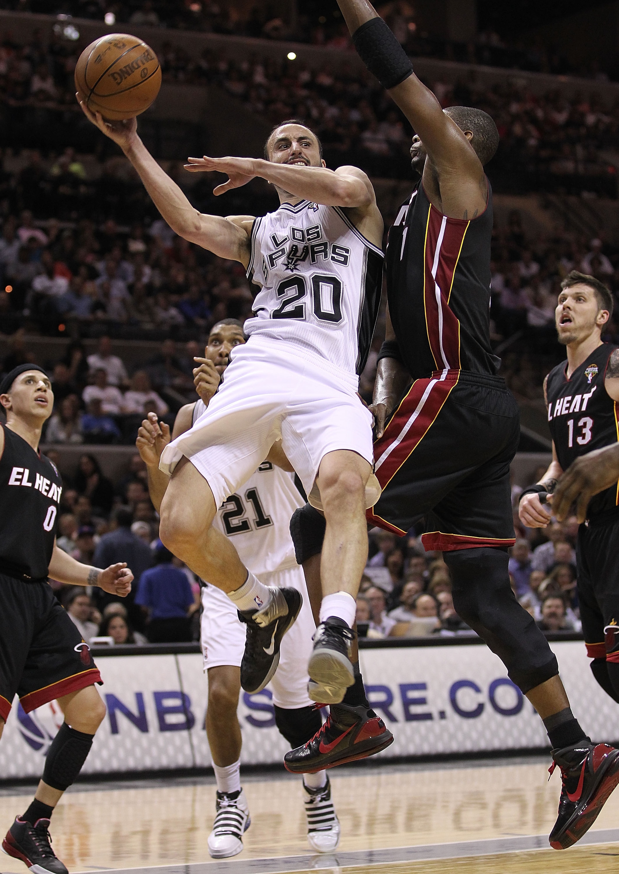 SAN ANTONIO, TX - MARCH 04:  Guard Manu Ginobili #20 of the San Antonio Spurs drives the lane against Chris Bosh #1 of the Miami Heat at AT&T Center on March 4, 2011 in San Antonio, Texas.   NOTE TO USER: User expressly acknowledges and agrees that, by do