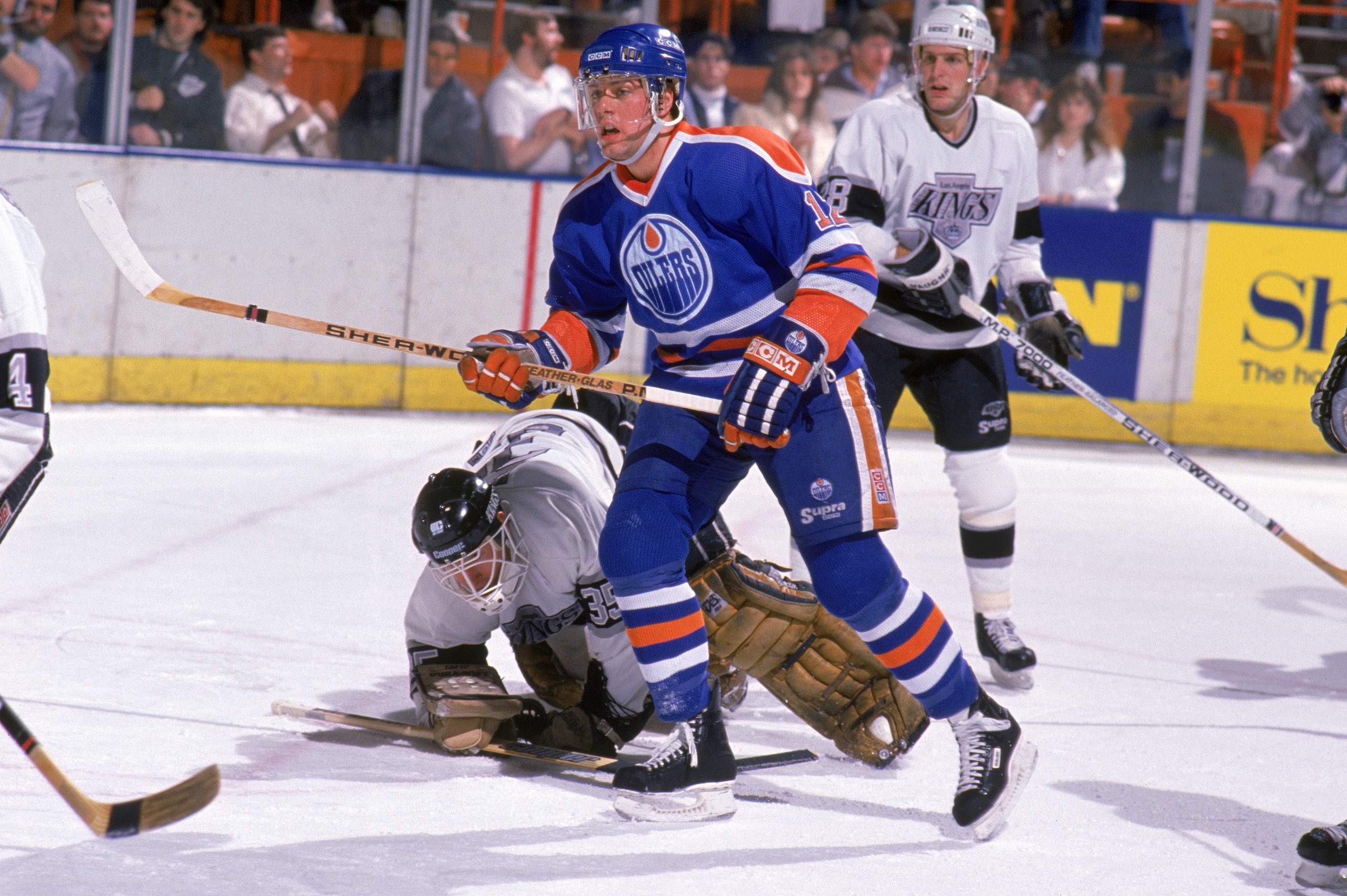 INGLEWOOD, CA - 1988:  Jimmy Carson #12 of the Edmonton Oilers skates past Los Angeles Kings goalkeeper Rob Stauber #35 who fall out of position in front of the crease during a game in 1988 at the Great Western Forum in Inglewood, California.  (Photo by M