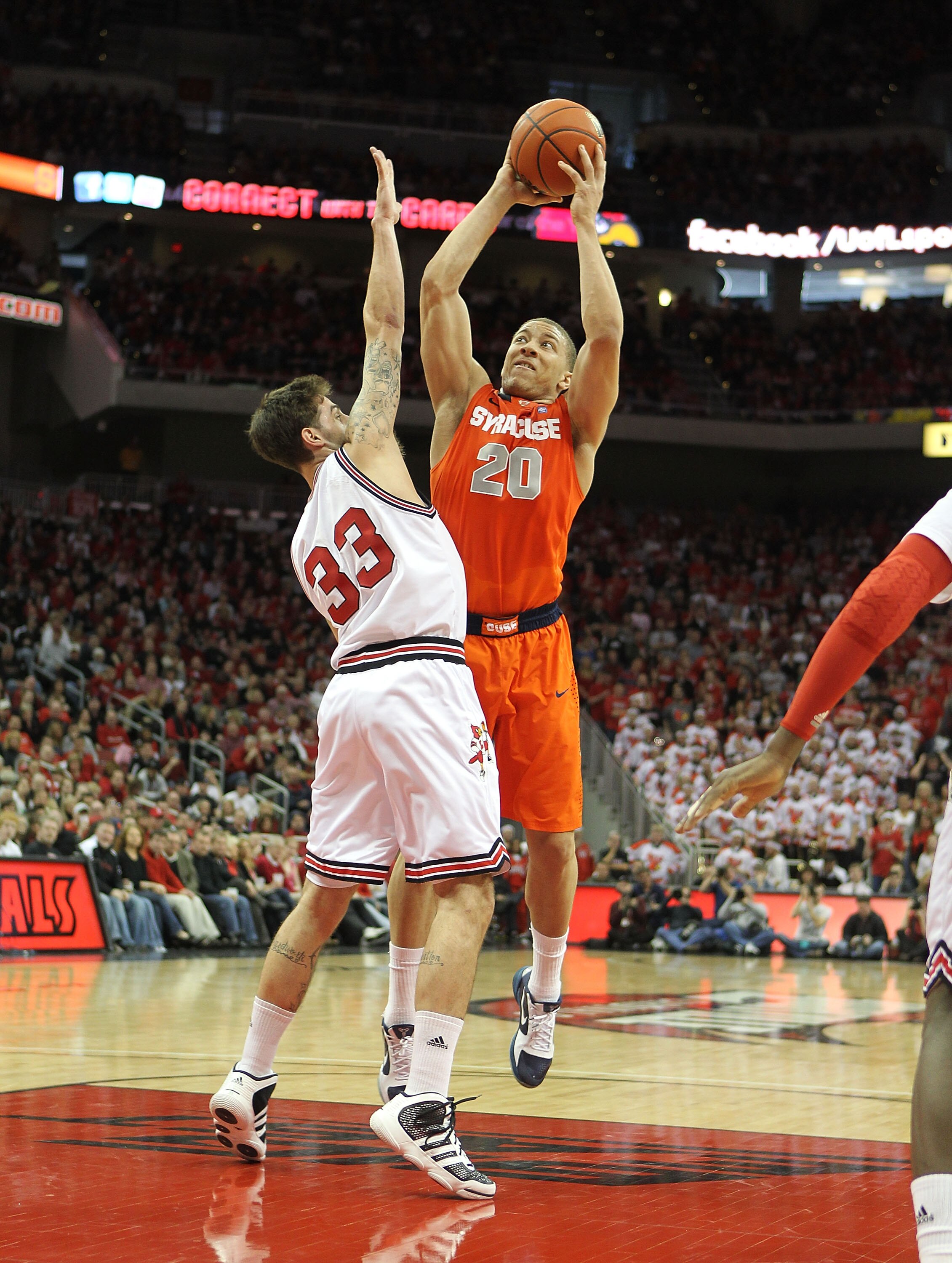 LOUISVILLE, KY - FEBRUARY 12:  Brandon Triche #20 of the Syracuse Orange shoots the ball while defended by Mike Marra #33 of the Louisville Cardinals during the Big East Conference game at the KFC Yum! Center on February 12, 2011 in Louisville, Kentucky.