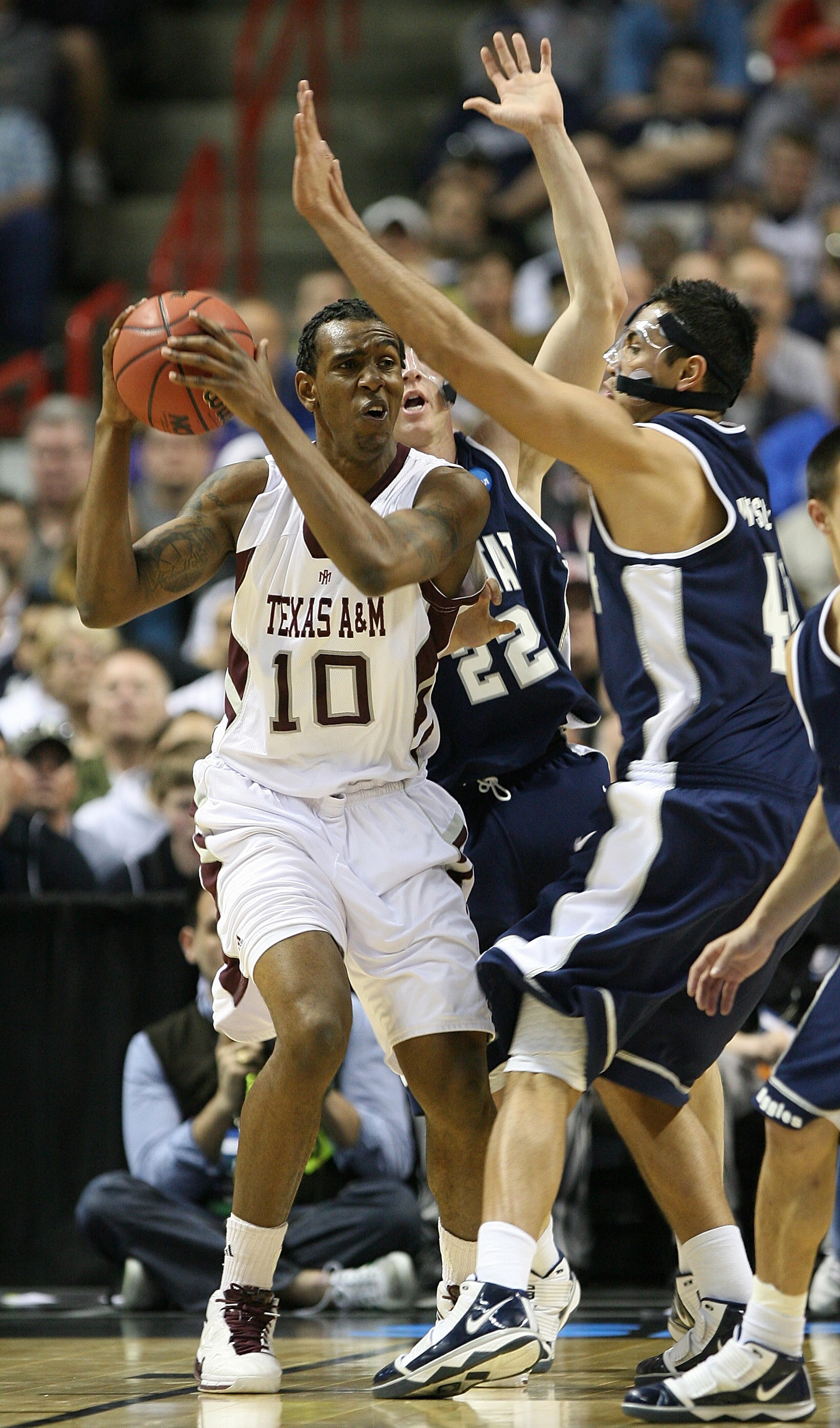 SPOKANE - MARCH 19:  David Loubeau #10 of the Texas A&M Aggies is pressured by Tai Wesley #42 and Brady Jardine #22 of the Utah State Aggies during the first round of the 2010 NCAA men's basketball tournament at the Spokane Arena on March 19, 2010 in Spok