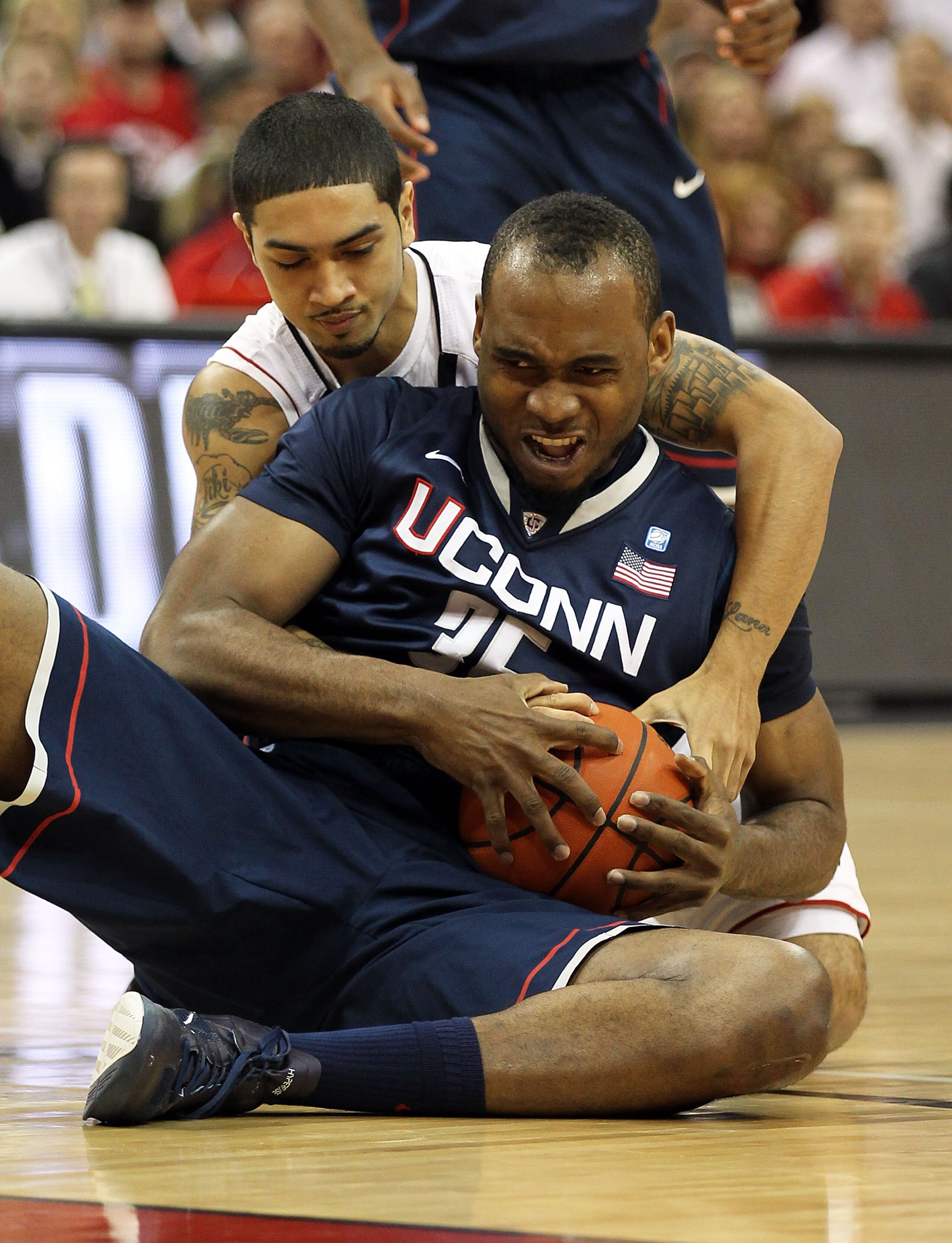 LOUISVILLE, KY - FEBRUARY 18:  Peyton Siva #3 of the Louisville Cardinals and Charles Okwandu #35 of the Connecticut Huskies battle for a loose ball during the Big East Conference game at the KFC Yum! Center on February 18, 2011 in Louisville, Kentucky.  