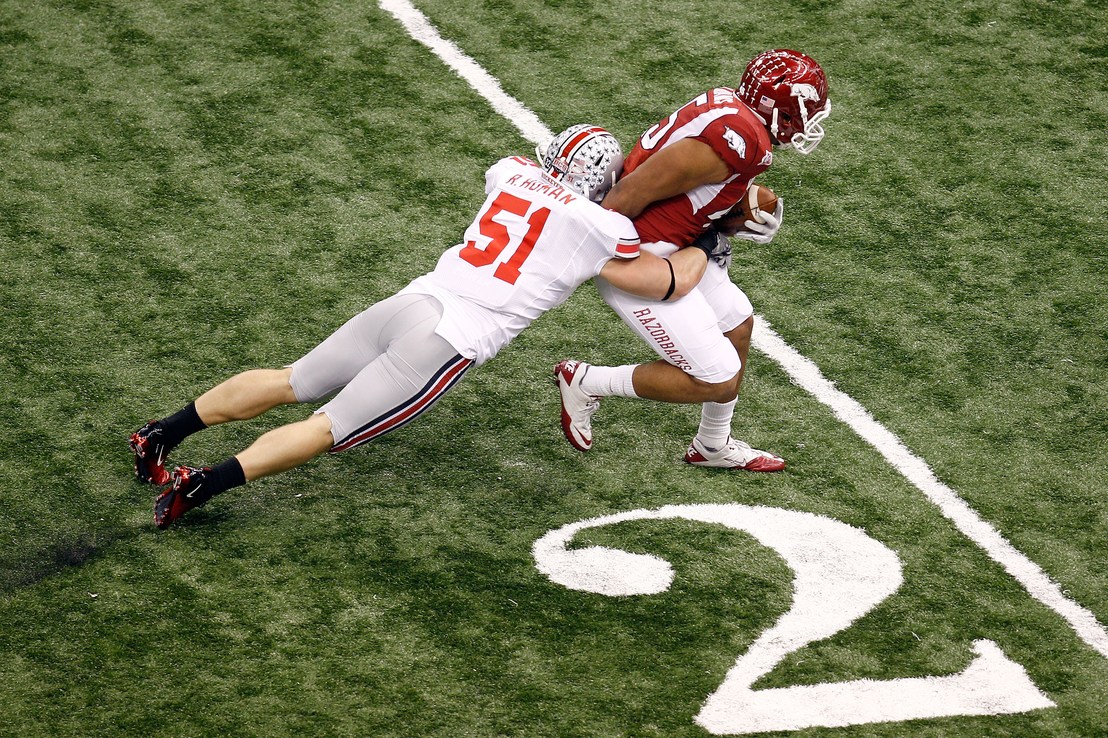 NEW ORLEANS, LA - JANUARY 04:  D.J. Williams #45 of the Arkansas Razorbacks attempts to not touch the ground as he tries to break a tackle by Ross Homan #51 of the Ohio State Buckeyes in the first half during the Allstate Sugar Bowl at the Louisiana Super