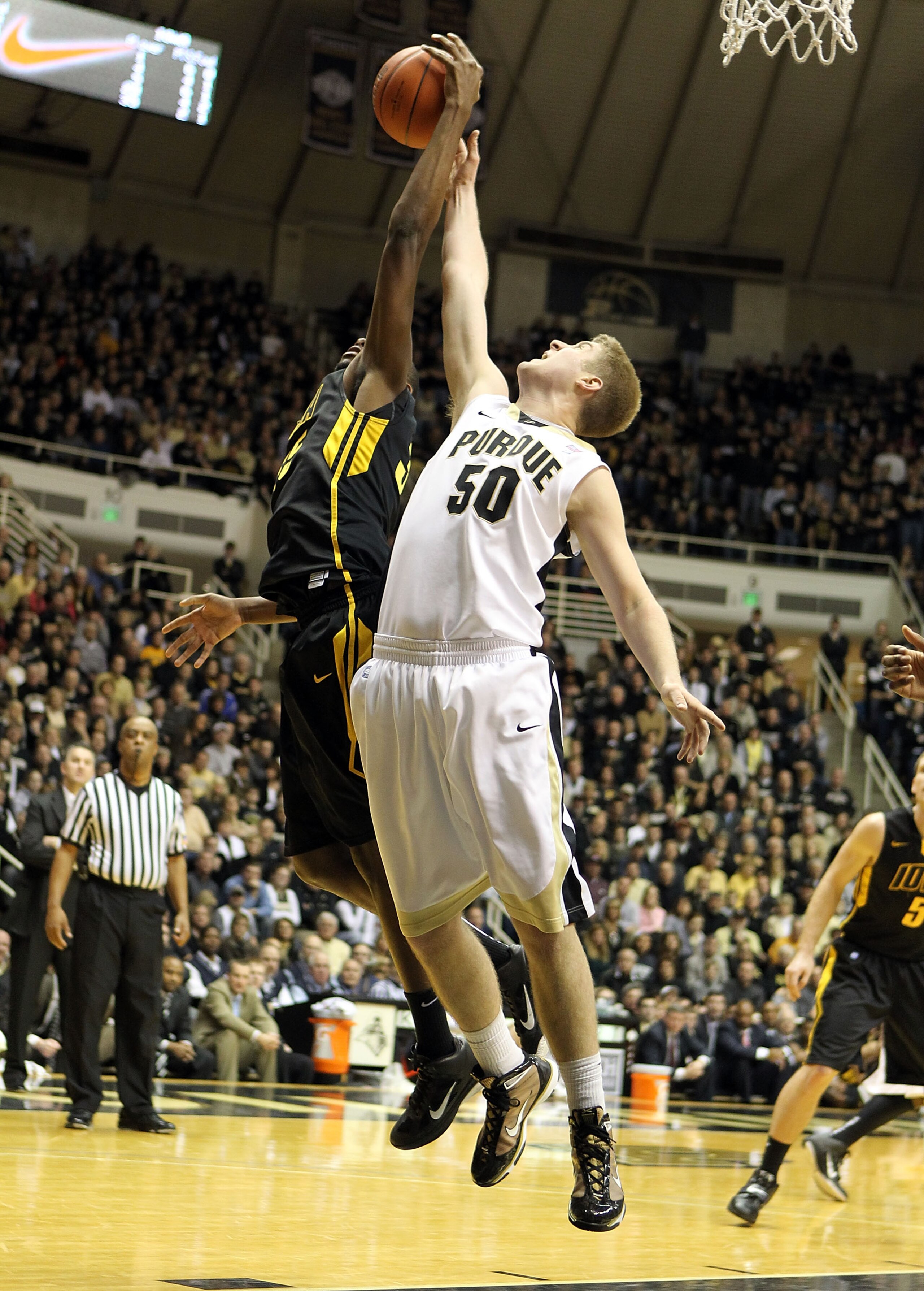WEST LAFAYETTE, IN - JANUARY 09:  Travis Carroll #50 of the Purdue Boilermakers reaches for a rebound against Devon Archie #35 of the Iowa Hawkeyes during the Big Ten Conference game at Mackey Arena on January 9, 2011 in West Lafayette, Indiana. Purdue wo