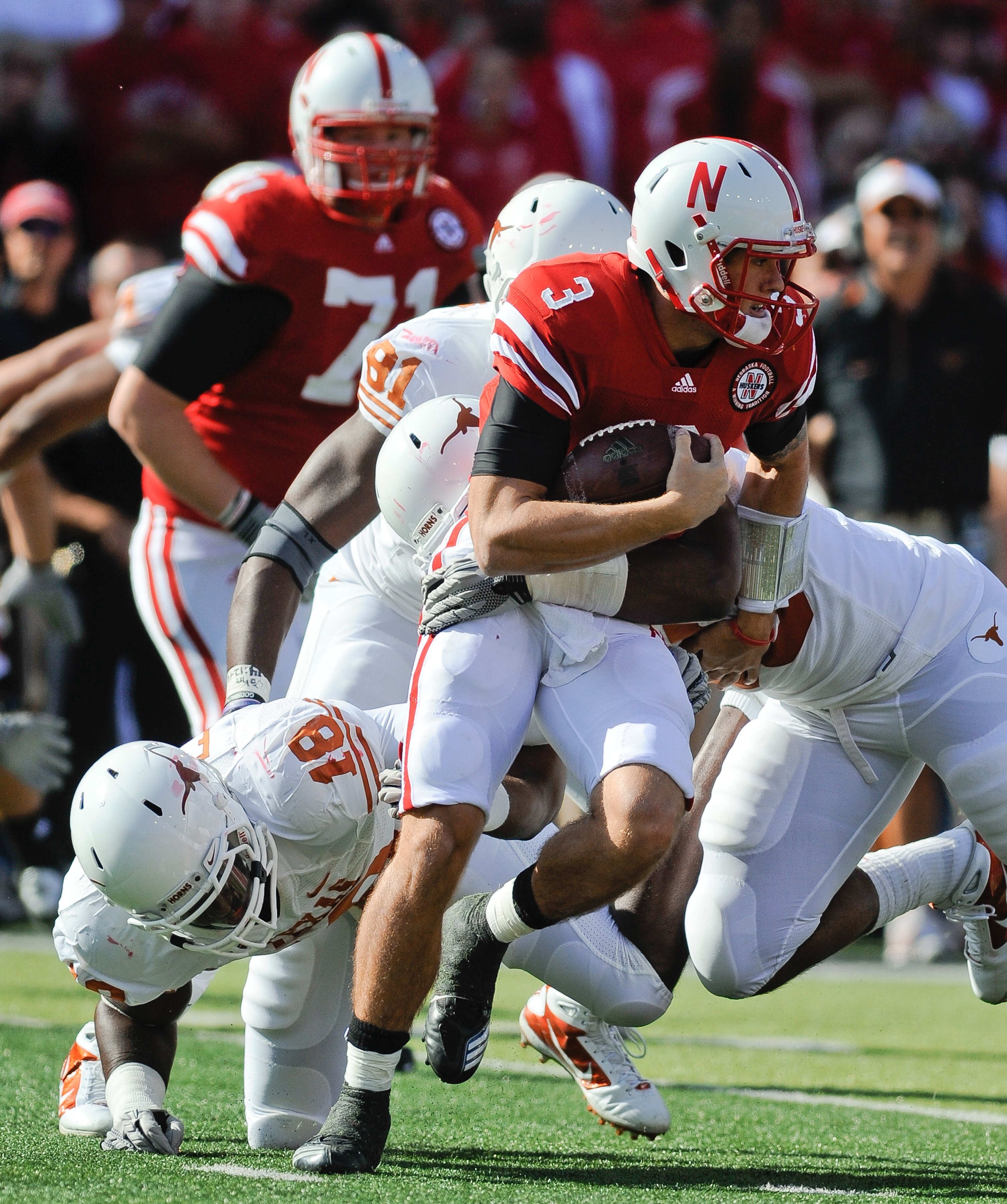 LINCOLN, NE - OCTOBER 16: Quarterback Taylor Martinez #3 of the Nebraska Cornhuskers runs from the grasp of Texas Longhorns linebacker Emmanuel Acho #18 during first half action of their game at Memorial Stadium on October 16, 2010 in Lincoln, Nebraska. T
