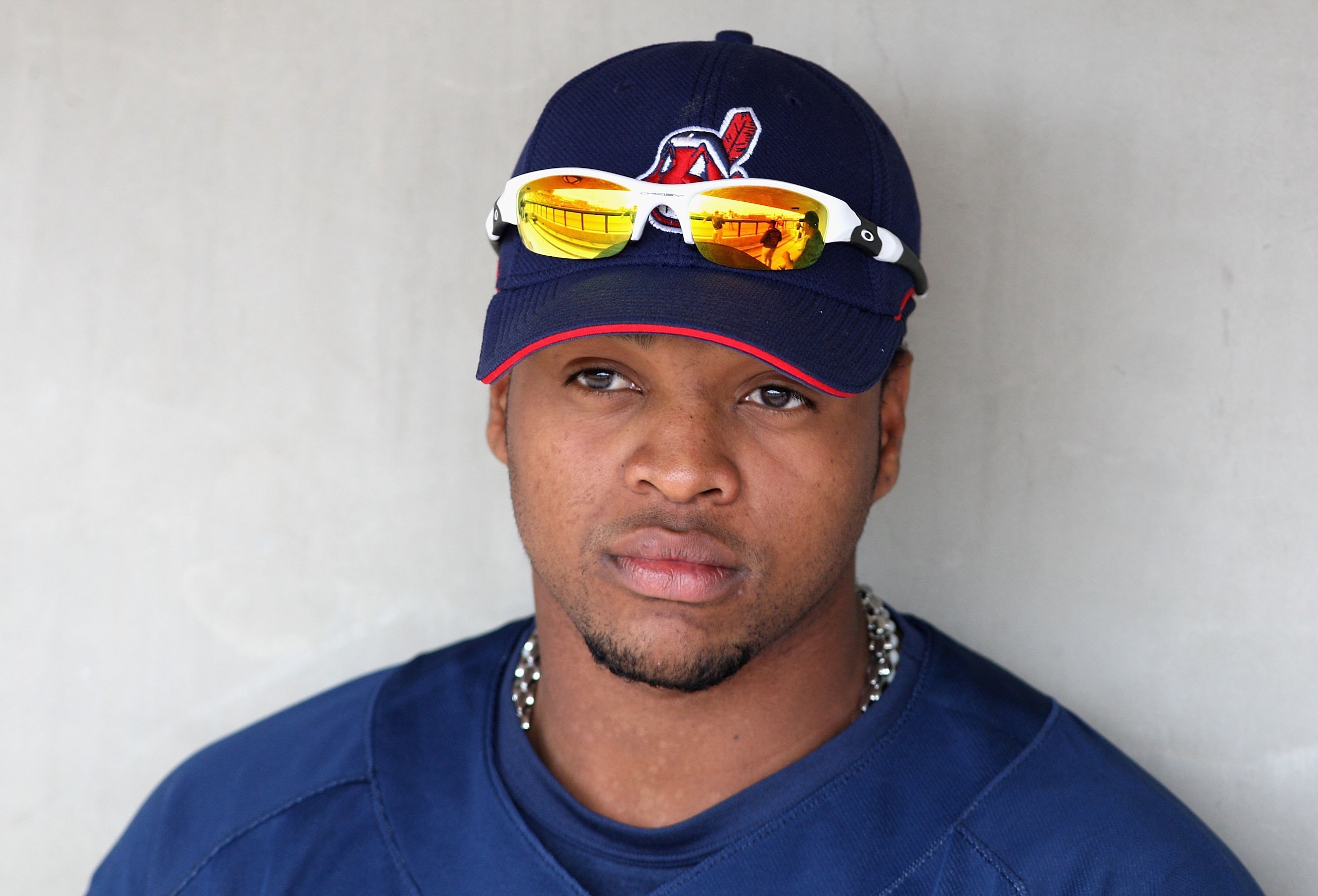 TEMPE, AZ - MARCH 08:  Carlos Santana #77 of the Cleveland Indians sits in the dutout before the spring training game against the Oakland Athletics at Phoenix Municipal Stadium on March 8, 2009 in Tempe, Arizona.  (Photo by Christian Petersen/Getty Images