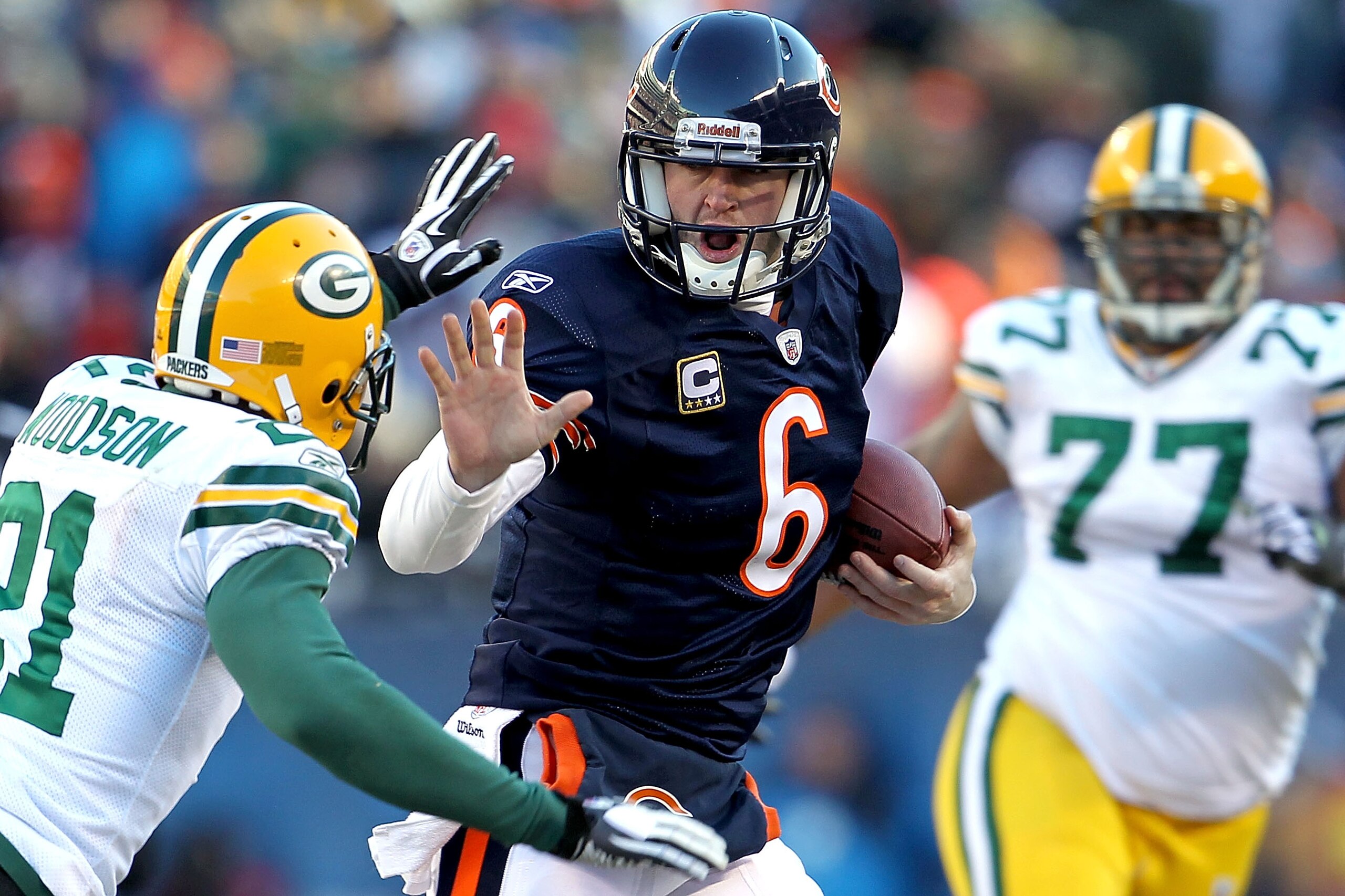 CHICAGO, IL - JANUARY 23:  Quarterback Jay Cutler #6 of the Chicago Bears throws out his right arm to avoid a tackle by Charles Woodson #21 of the Green Bay Packers in the second quarter of the NFC Championship Game at Soldier Field on January 23, 2011 in