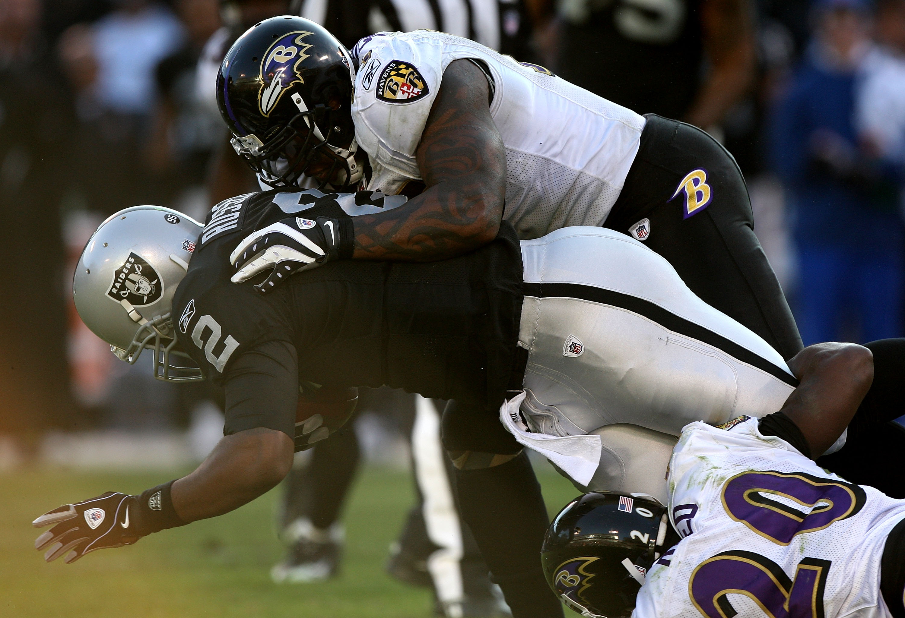 OAKLAND, CA - JANUARY 3: Terrell Suggs #55 of the Baltimore Ravens tackles JaMarcus Russell #2 of the Oakland Raiders during an NFL game at Oakland-Alameda County Coliseum on January 3, 2010 in Oakland, California. (Photo by Jed Jacobsohn/Getty Images)