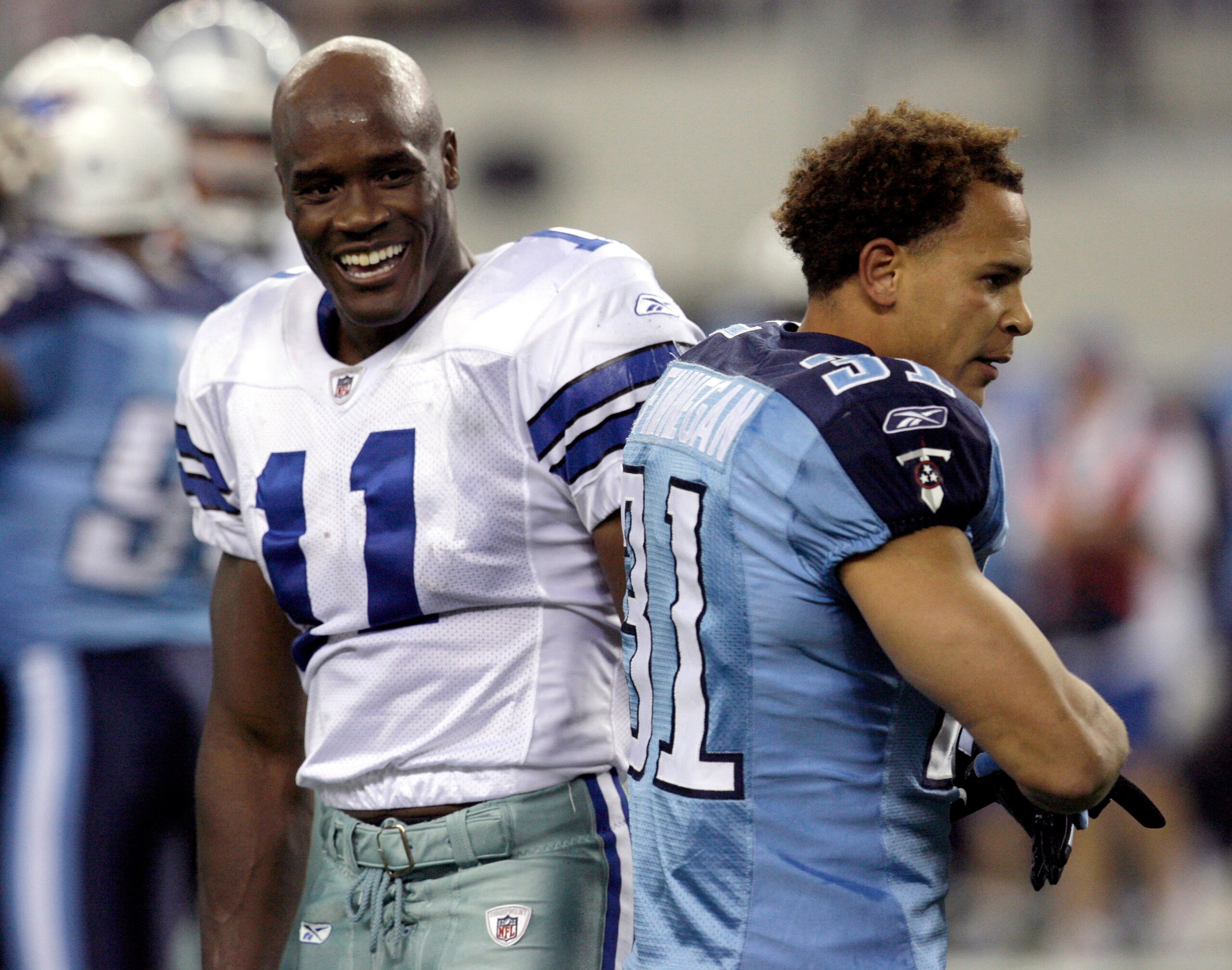 ARLINGTON, TX - AUGUST 21:  Wide receiver Roy Williams #11 of the Dallas Cowboys (left) reacts after losing his helmet on a play the first quarter against corner back Cortland Finnegan #31 ofthe Tennessee Titans during a preseason game at Cowboys Stadium