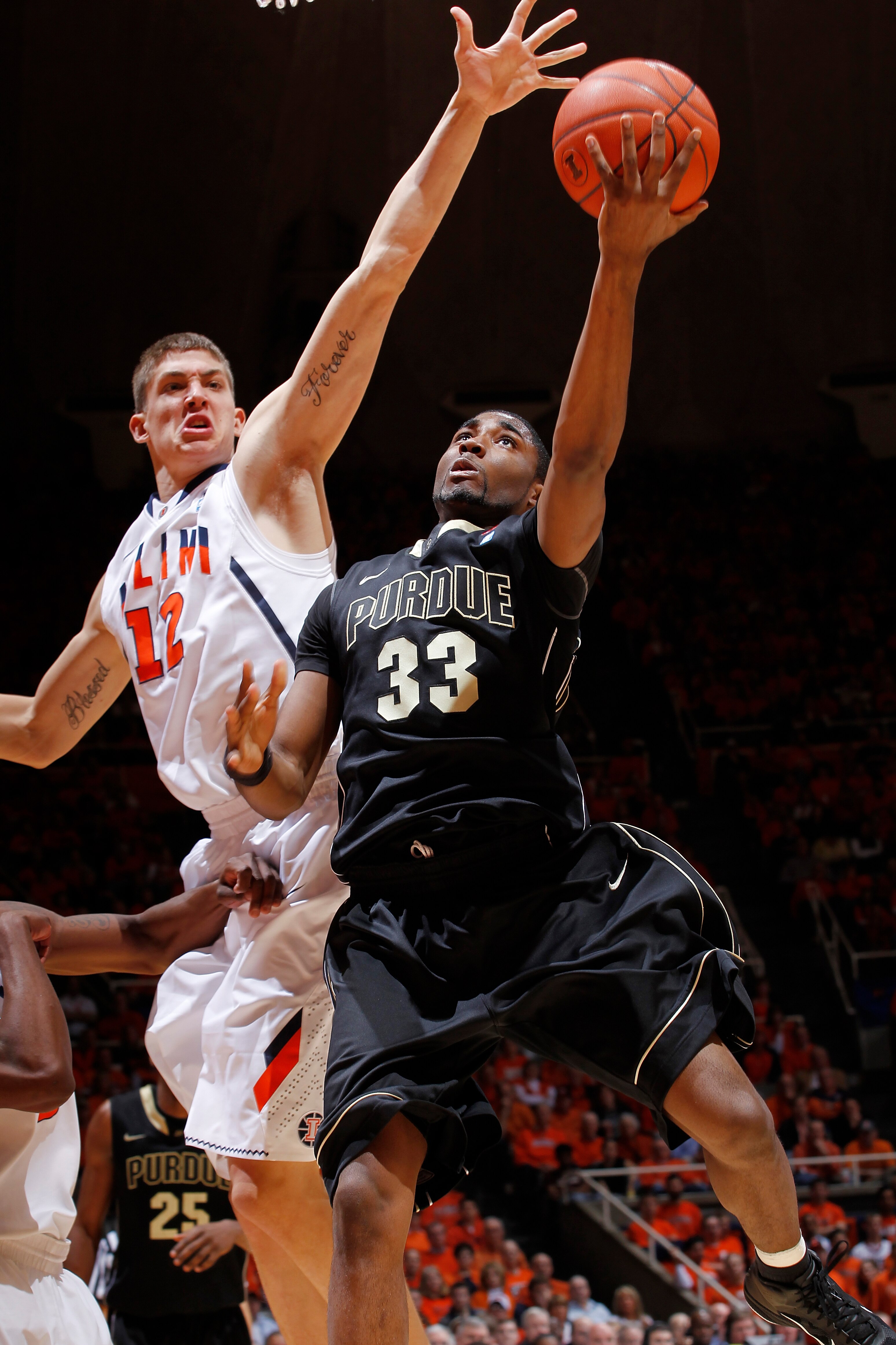 CHAMPAIGN, IL - FEBRUARY 13: E'Twaun Moore #33 of the Purdue Boilermakers goes to the basket past Meyers Leonard #12 of the Illinois Fighting Illini at Assembly Hall on February 13, 2011 in Champaign, Illinois. Purdue defeated Illinois 81-70. (Photo by Jo