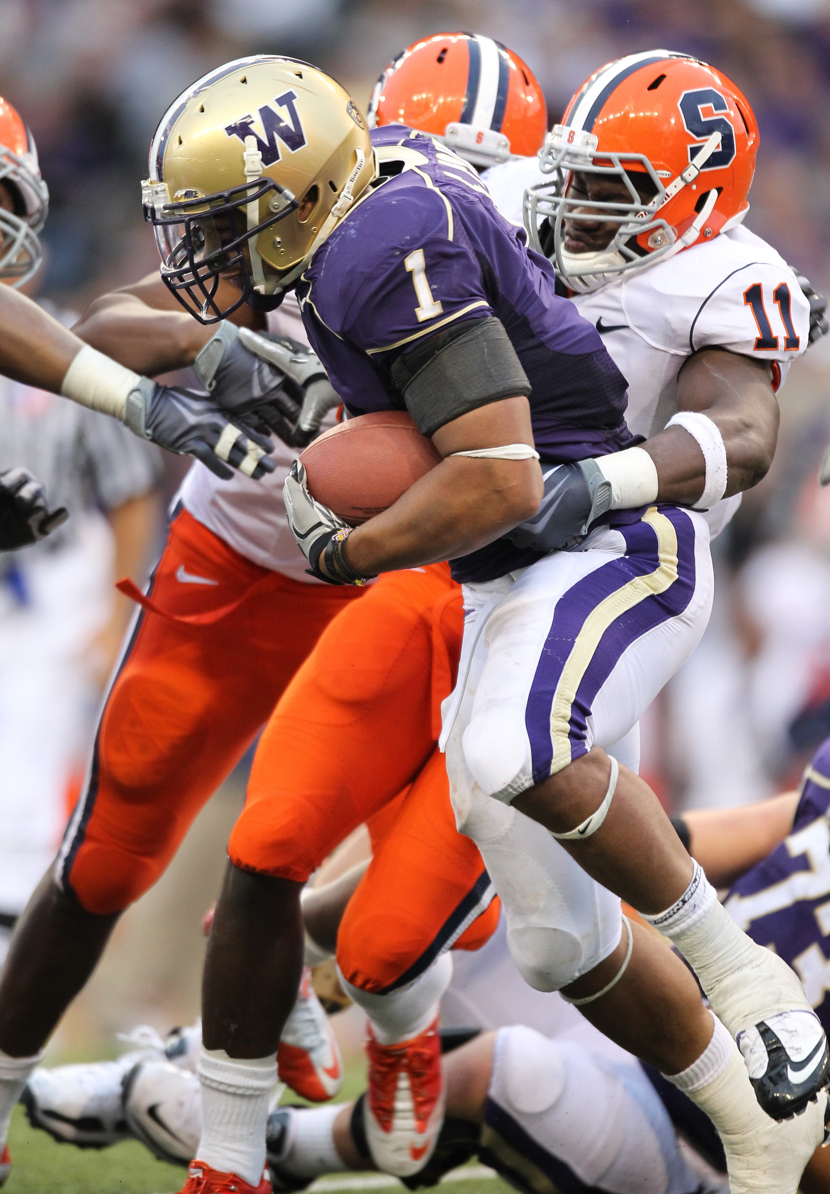 SEATTLE - SEPTEMBER 11:  Running back Chris Polk #1 of the Washington Huskies rushes against Marquis Spruill #11 of the Syracuse Orange on September 11, 2010 at Husky Stadium in Seattle, Washington. (Photo by Otto Greule Jr/Getty Images)