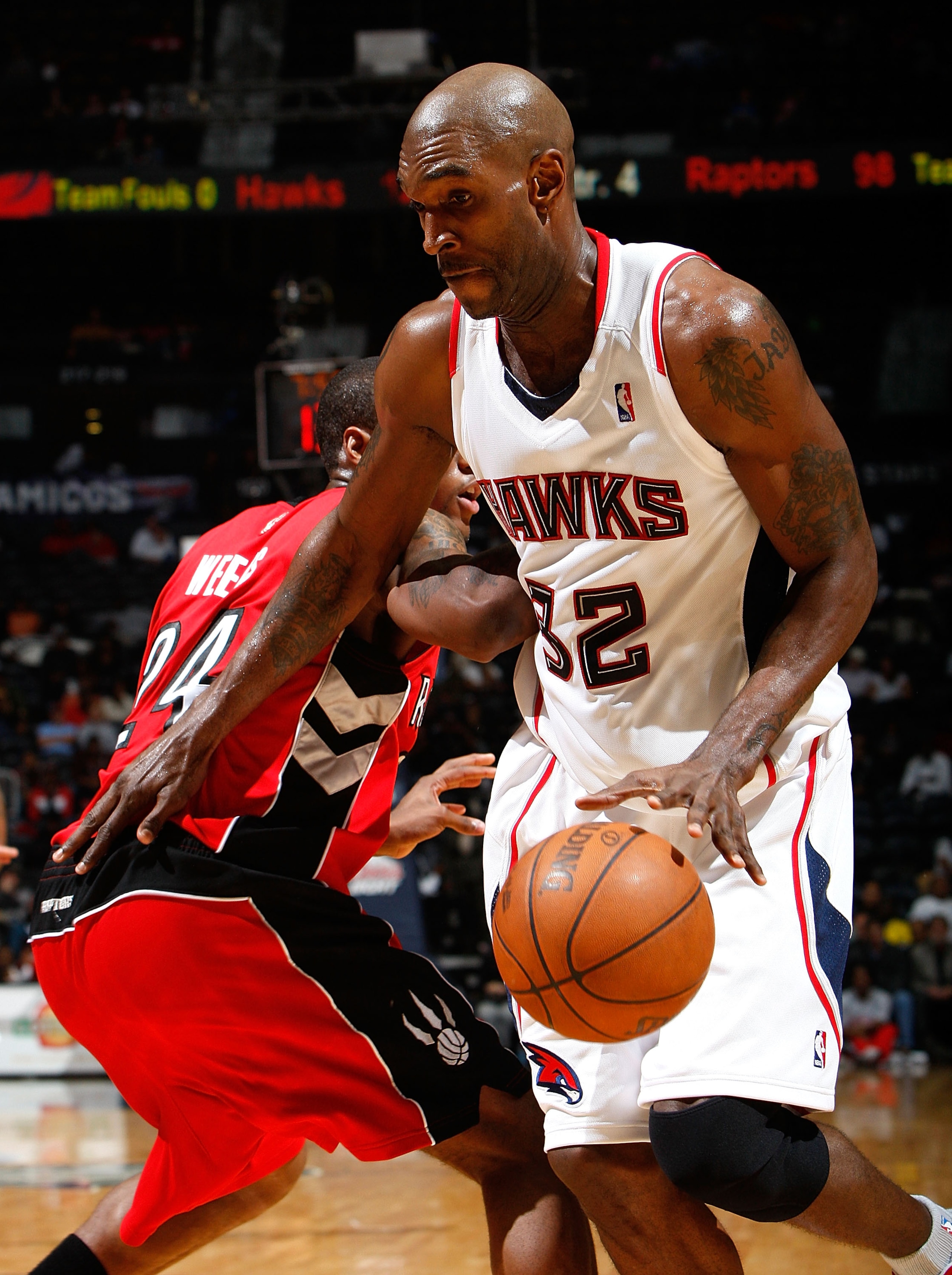 ATLANTA - DECEMBER 02:  Joe Smith #32 of the Atlanta Hawks drives against Sonny Weems #24 of the Toronto Raptors at Philips Arena on December 2, 2009 in Atlanta, Georgia.  NOTE TO USER: User expressly acknowledges and agrees that, by downloading and/or us