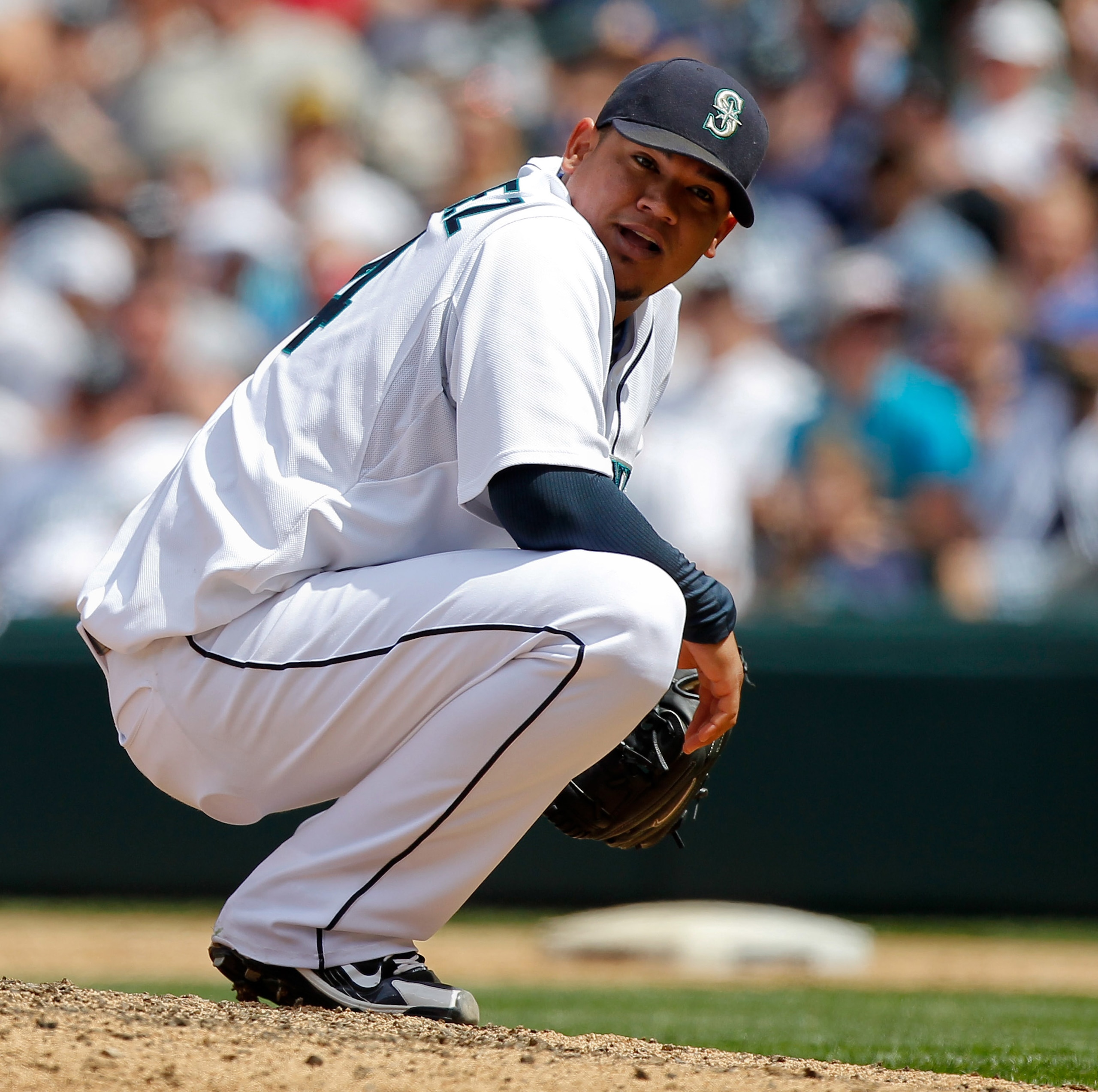 SEATTLE - JUNE 24: Starting pitcher Felix Hernandez #34 of the Seattle Mariners looks back at third baseman Jose Lopez after having to duck his throw to first base on a ground out by Ryan Theriot of the Chicago Cubs at Safeco Field on June 24, 2010 in Sea