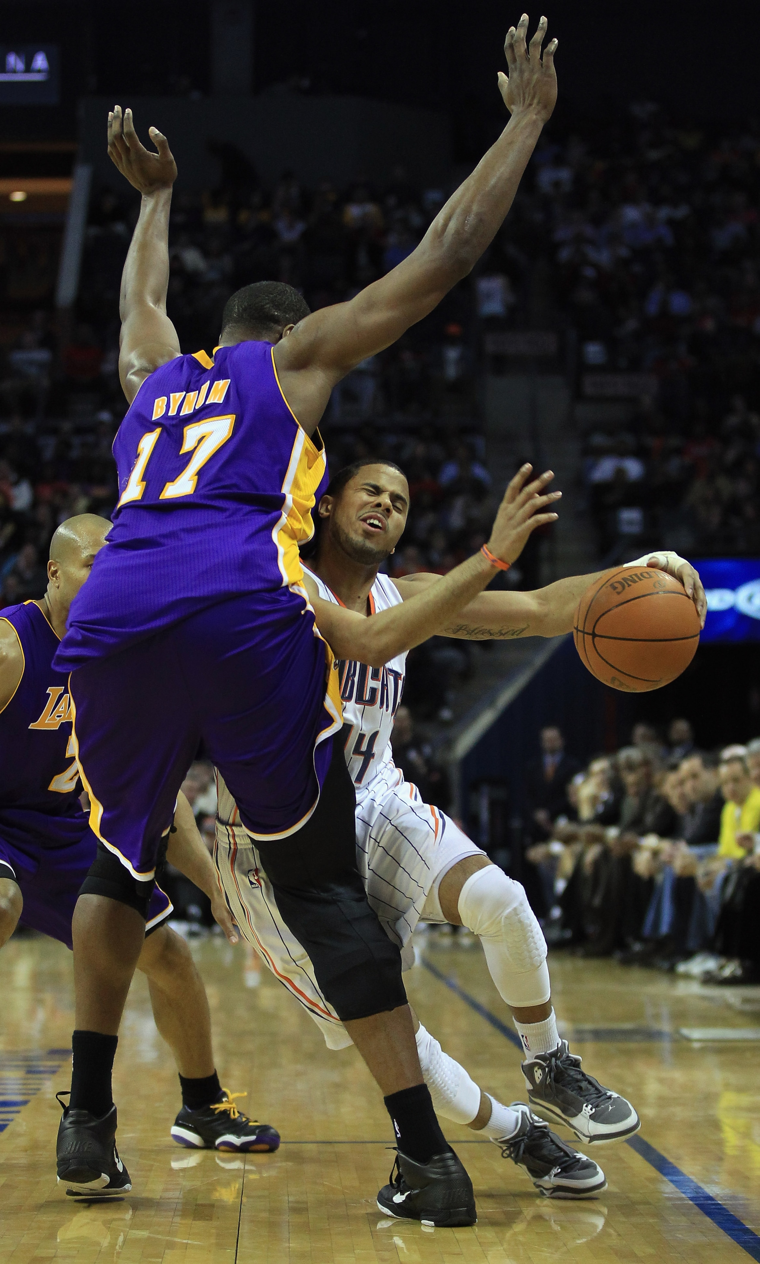 CHARLOTTE, NC - FEBRUARY 14:  Andrew Bynum #17 of the Los Angeles Lakers fouls D.J. Augustin #14 of the Charlotte Bobcats during their game at Time Warner Cable Arena on February 14, 2011 in Charlotte, North Carolina. NOTE TO USER: User expressly acknowle