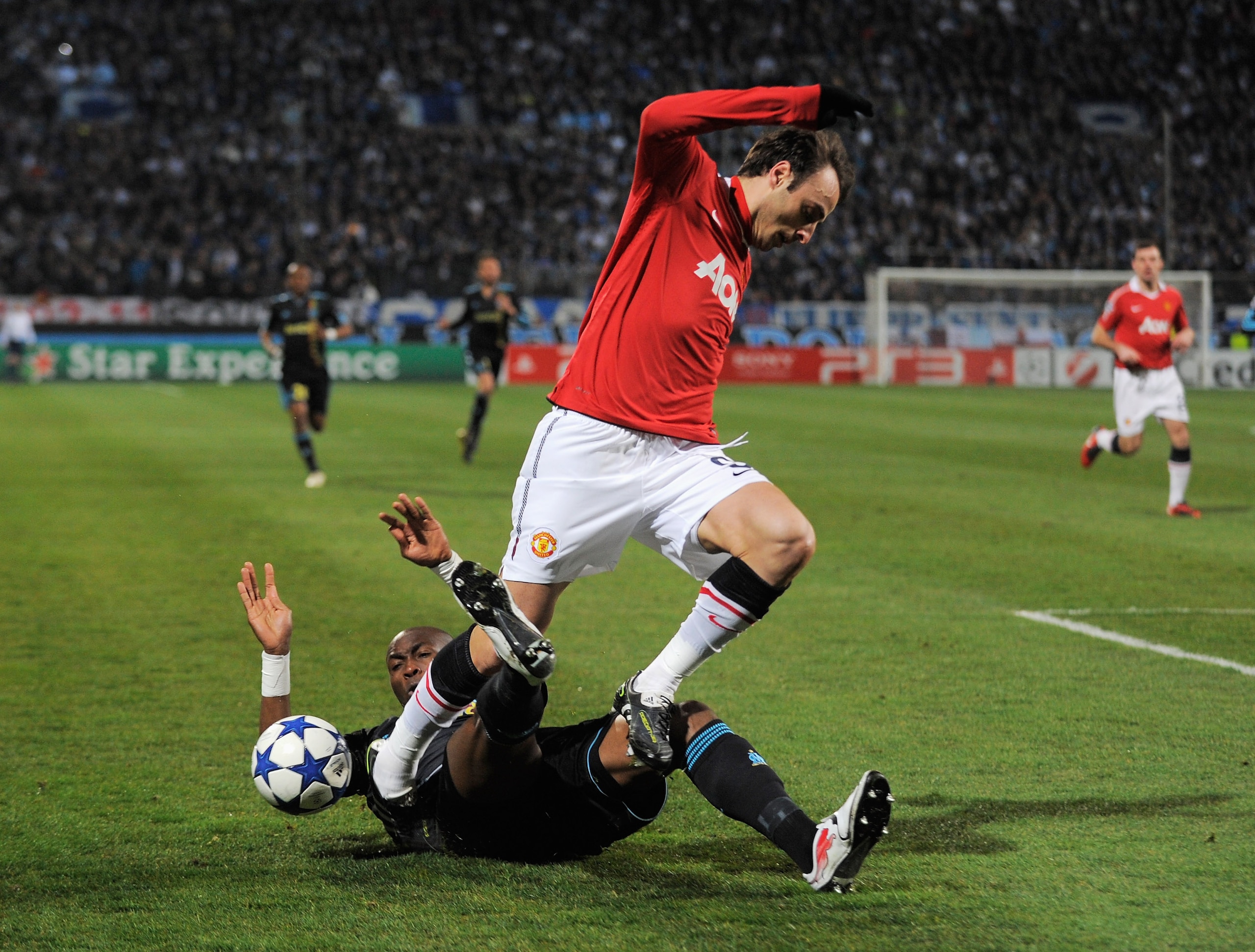 MARSEILLE, FRANCE - FEBRUARY 23:  Dimitar Berbatov of Manchester United is challenged by Stephane Mbia of Marseille during the UEFA Champions League round of 16 first leg match between Marseille and Manchester United at the Stade Velodrome on February 23,