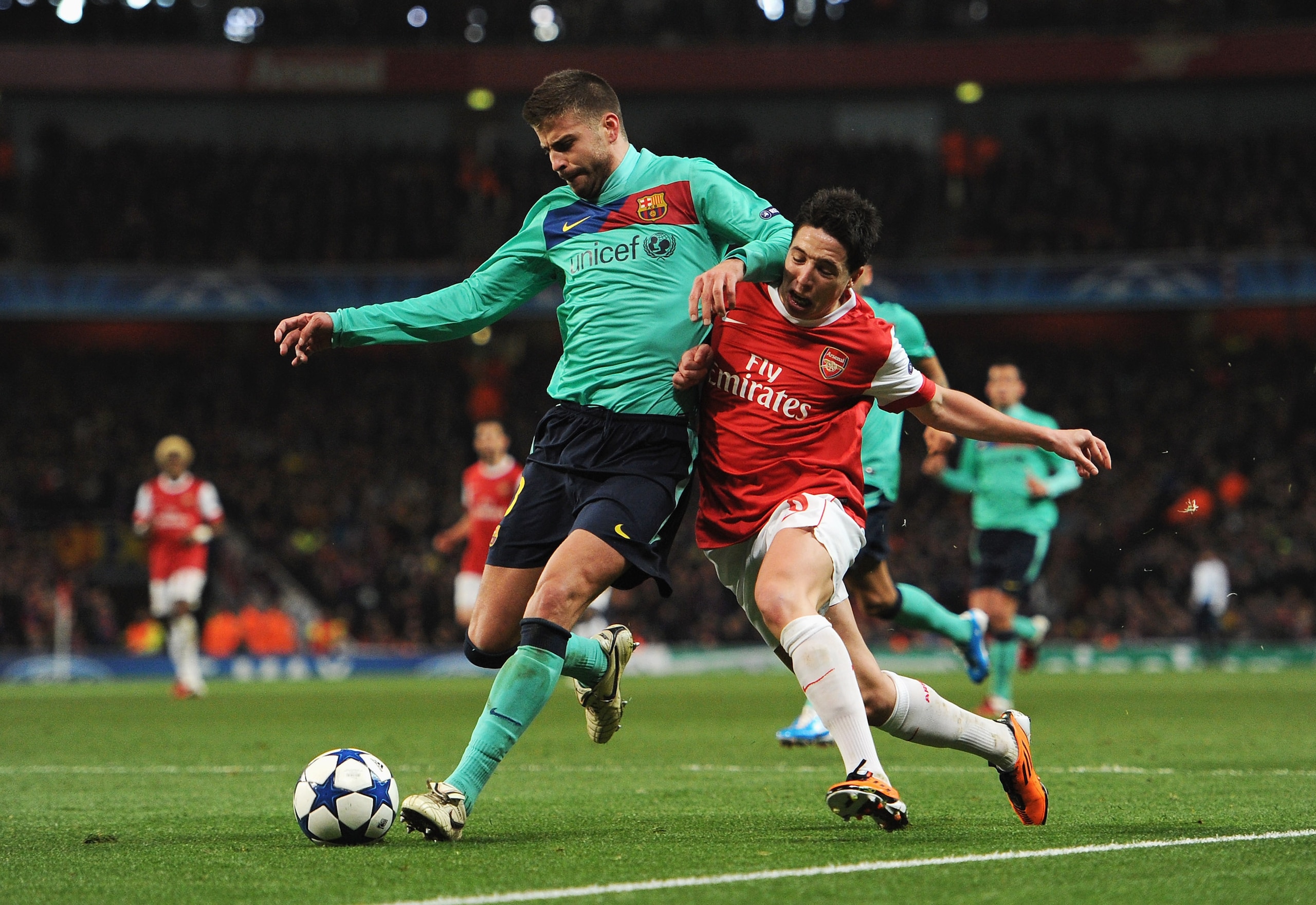 LONDON, ENGLAND - FEBRUARY 16: Samir Nasri of Arsenal challenges Gerard Pique of Barcelona during the UEFA Champions League round of 16 first leg match between Arsenal and Barcelona at the Emirates Stadium on February 16, 2011 in London, England.  (Photo