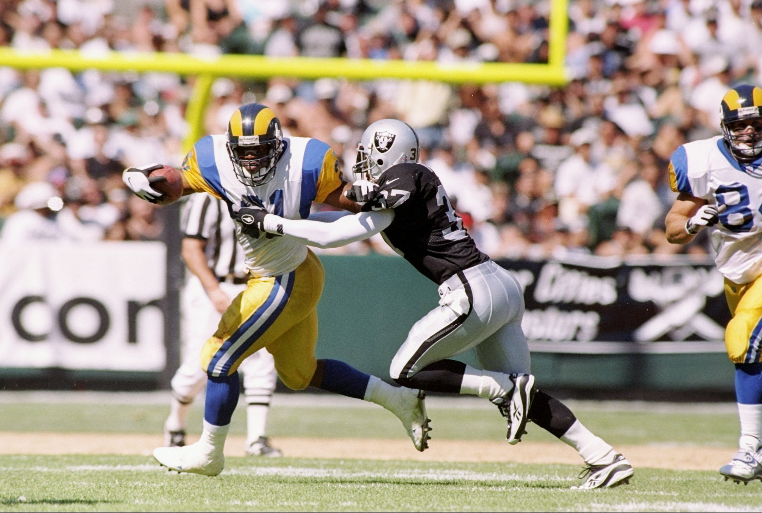 28 Sep 1997:  Running back Lawrence Phillips (left) of the St. Louis Rams tries to avoid an arm tackle by defensive back James Trapp #37 of the Oakland Raiders during the Rams 35-17 loss at UMAX Stadium in Oakland, California. Mandatory Credit: Otto Greul