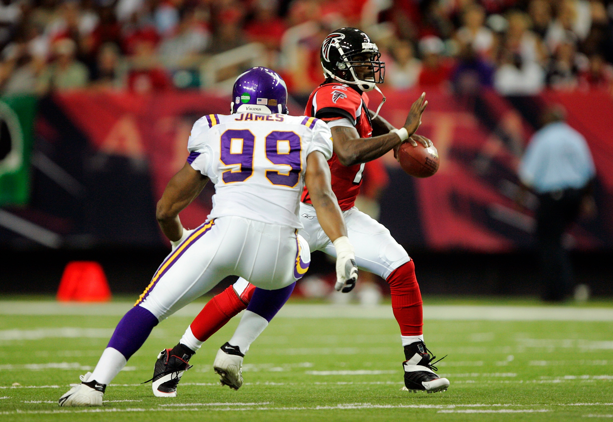 ATLANTA - OCTOBER 2:  Quarterback Michael Vick #7 of the Atlanta Falcons doubles back as he gets caught in the backfield rolling out by defensive end Erasmus James #99 of the Minnesota Vikings in the second quarter on October 2, 2005 at the Georgia Dome i
