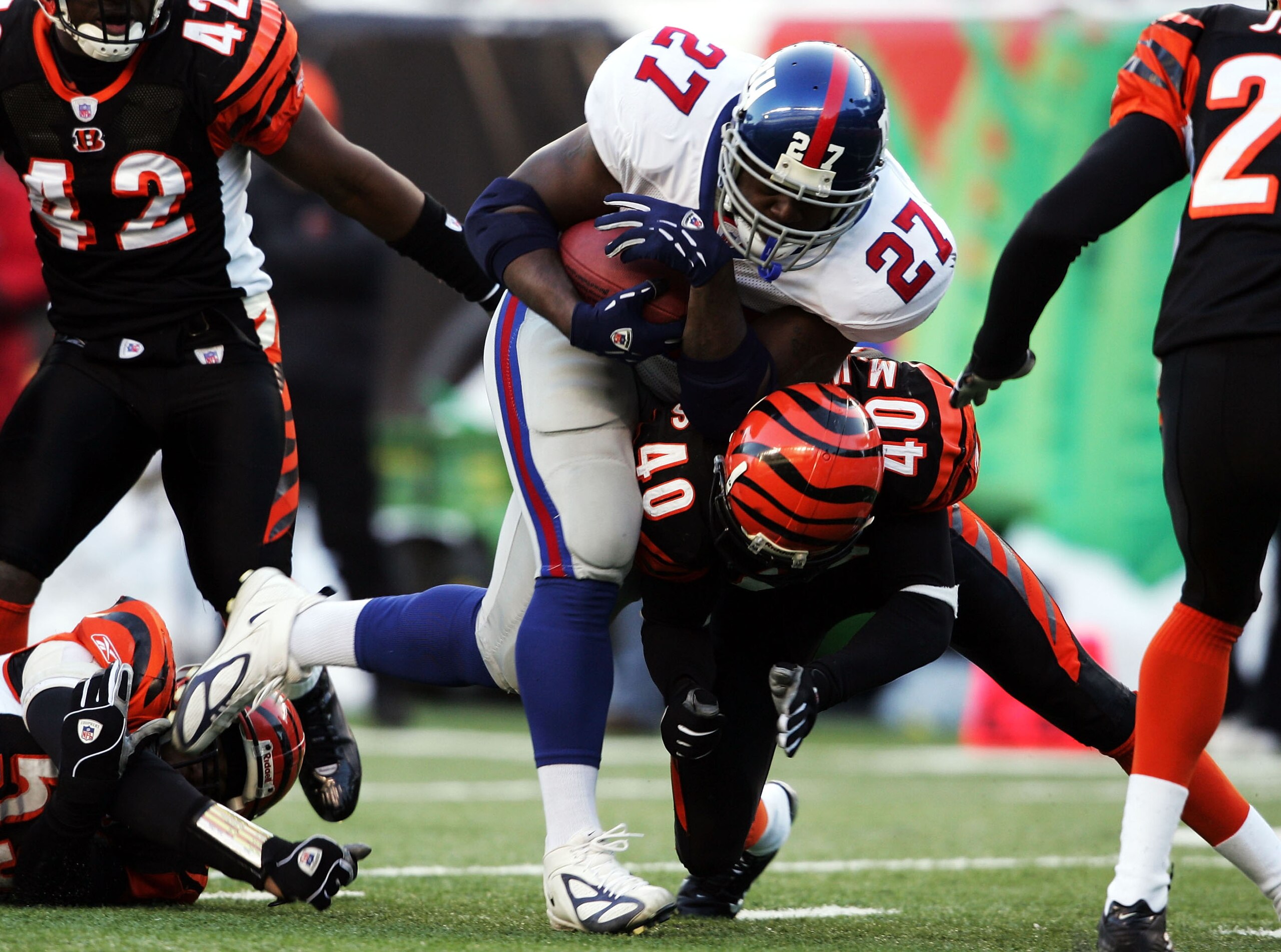CINCINNATI - DECEMBER 26:  Ron Dayne #27 of the New York Giants is tackled by Madieu Williams #40 of the Cincinnati Bengals during the NFL game on December 26, 2004 at Paul Brown Stadium in Cincinnati, Ohio. The Bengsals won 23-22.  (Photo by Andy Lyons/G