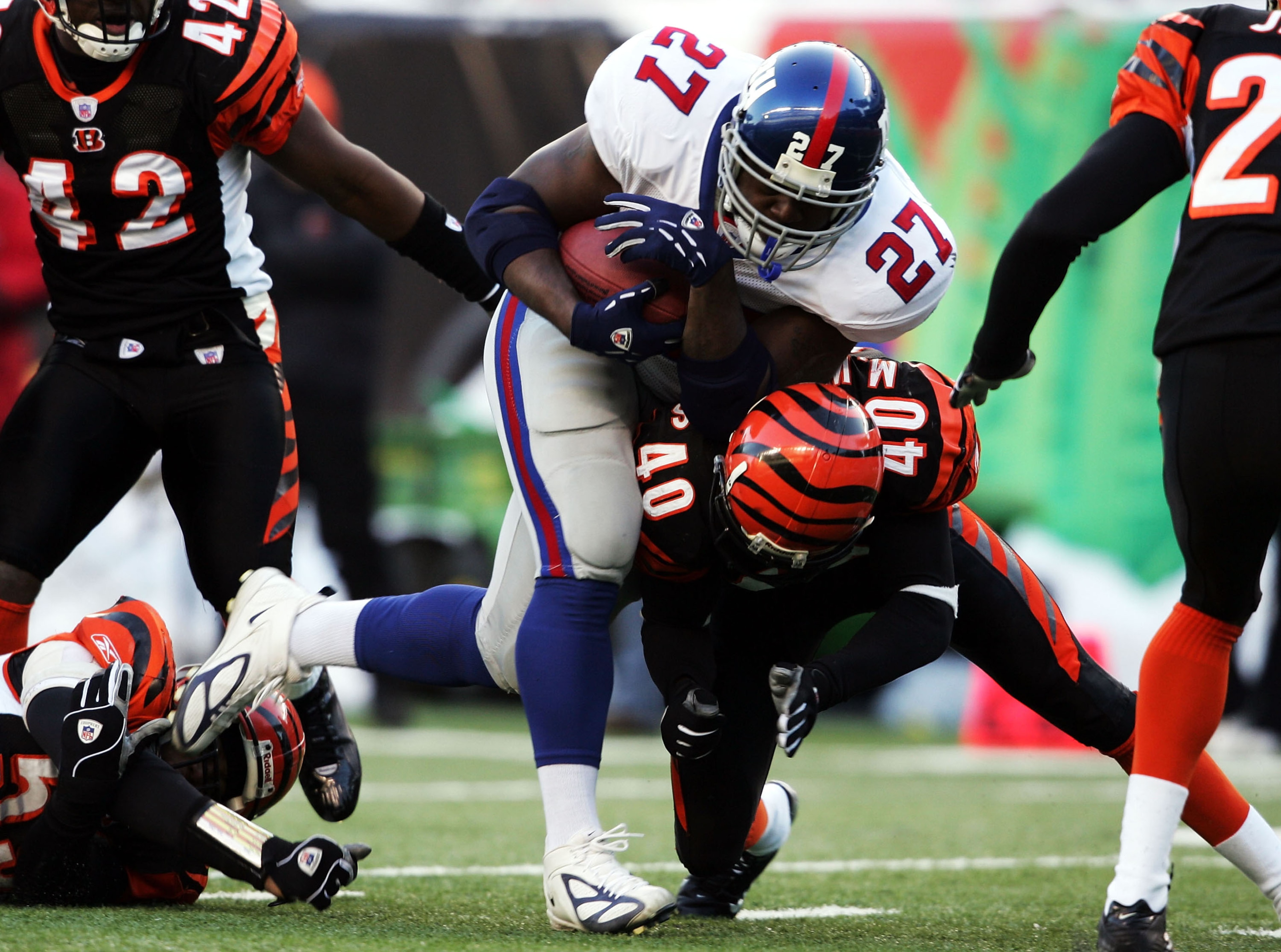 CINCINNATI - DECEMBER 26:  Ron Dayne #27 of the New York Giants is tackled by Madieu Williams #40 of the Cincinnati Bengals during the NFL game on December 26, 2004 at Paul Brown Stadium in Cincinnati, Ohio. The Bengsals won 23-22.  (Photo by Andy Lyons/G