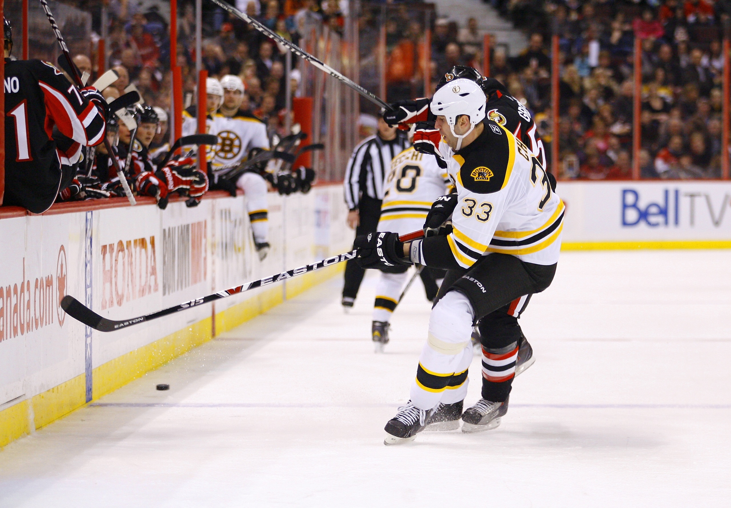 OTTAWA, CANADA - MARCH 01:  Zdeno Chara #33 of the Boston Bruins takes a bodycheck from Colin Greening #52 of the Ottawa Senators as he tries to carry the puck up ice in a game at Scotiabank Place on March 1, 2011 in Ottawa, Canada.  (Photo by Phillip Mac