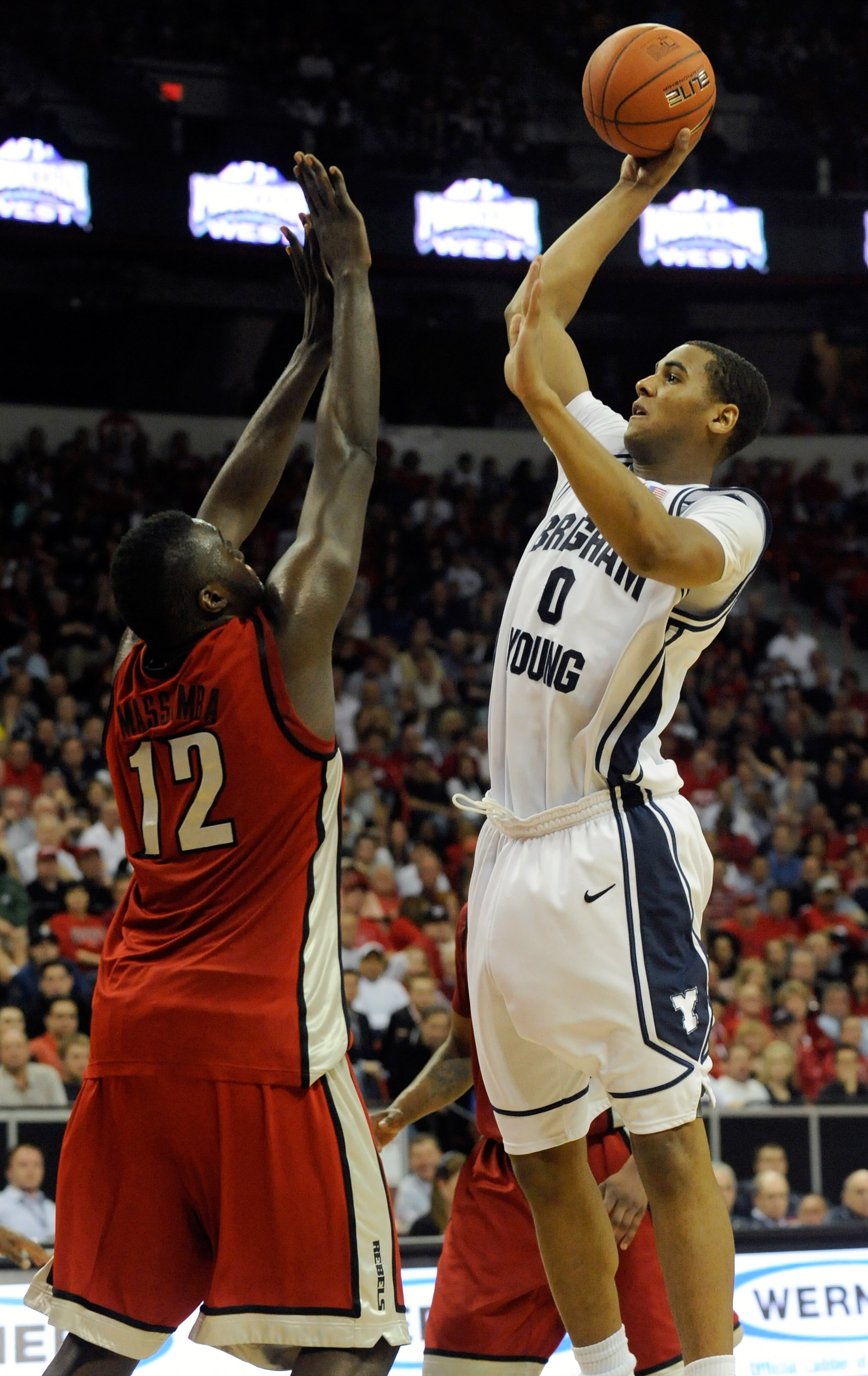 LAS VEGAS - MARCH 12:  Brandon Davies #0 of the Brigham Young University Cougars shoots over Brice Massamba #12 of the UNLV Rebels during a semifinal game of the Conoco Mountain West Conference Basketball tournament at the Thomas & Mack Center March 12, 2