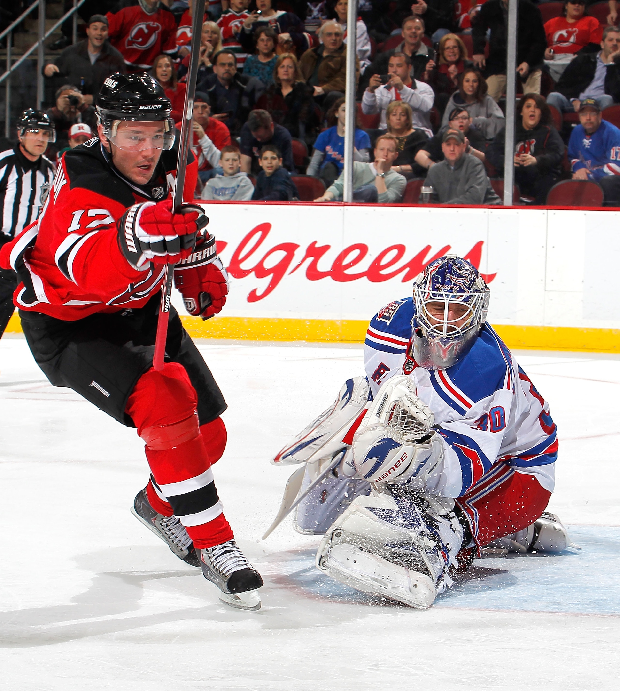 NEWARK, NJ - FEBRUARY 18:  Ilya Kovalchuk #17 of the New Jersey Devils begins to celebrate his goal as goalie Henrik Lundqvist #30 of the New York Rangers looks back towards the goal in the second period of an NHL hockey game at the Prudential Center on F