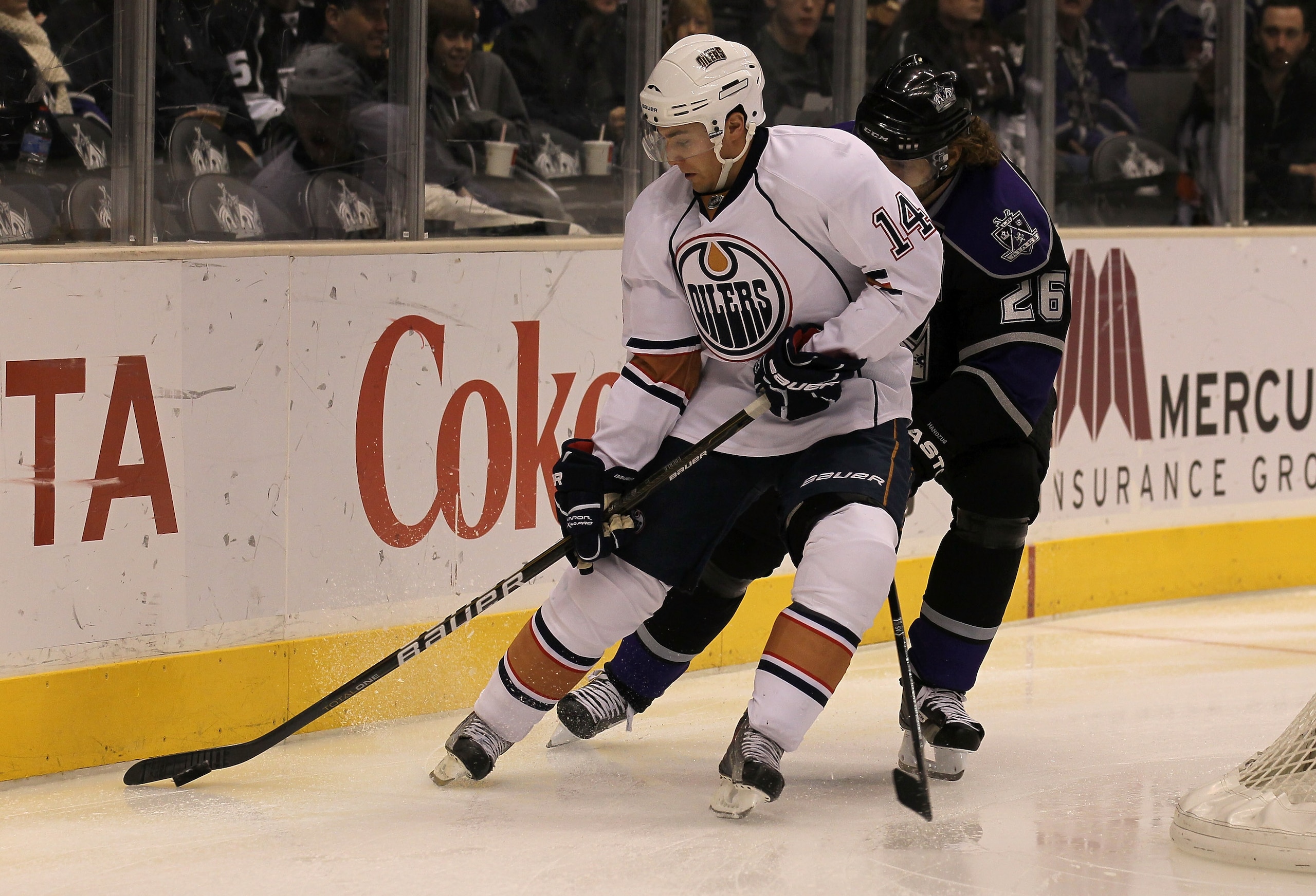 LOS ANGELES, CA - DECEMBER 23: Jordan Eberle #14 of the Edmonton Oilers controls the puck against Mechal Handzus #26 of the Los Angeles Kings at Staples Center on December 23, 2010 in Los Angeles, California. (Photo by Stephen Dunn/Getty Images)