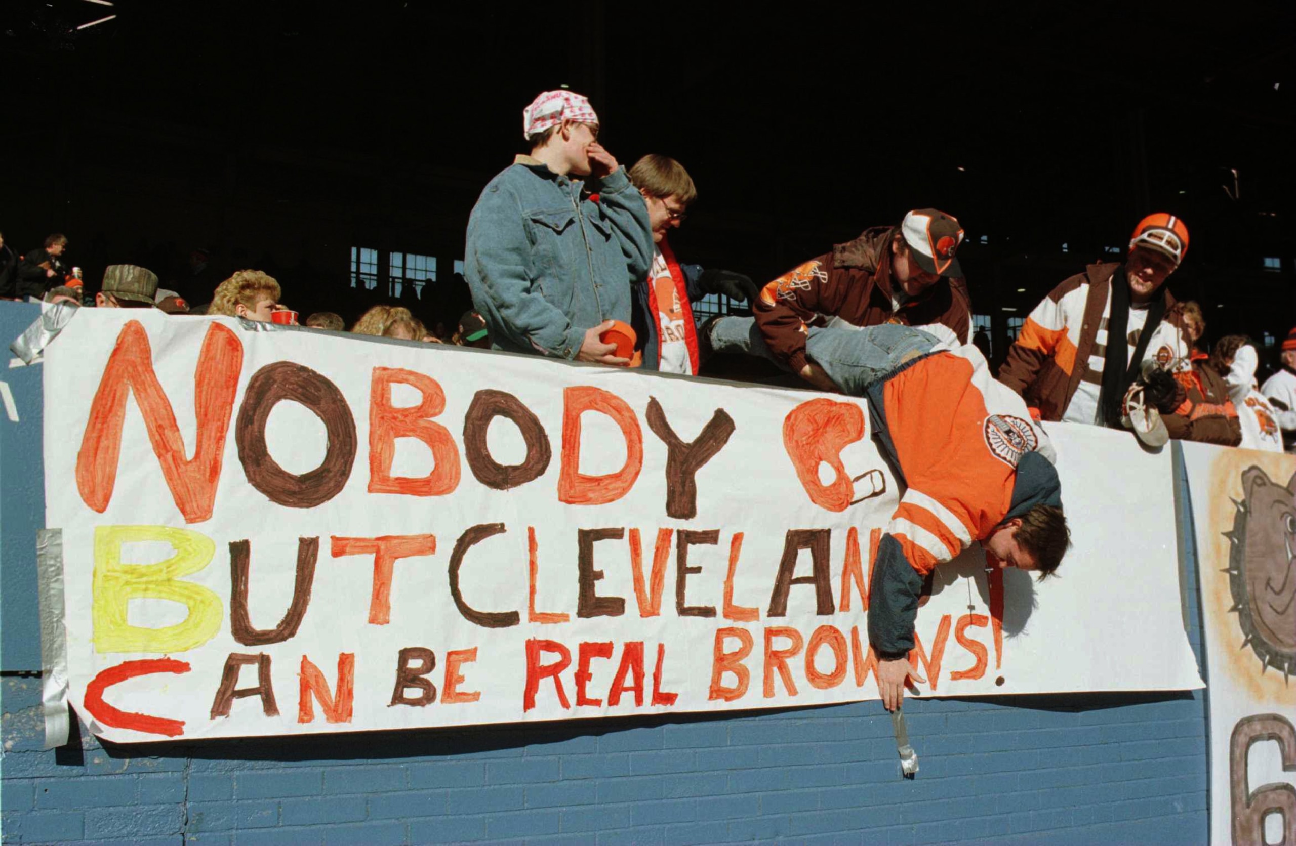 17 DEC 1995:  BROWNS FAN KENNY TAYLOR IS HELD BY HIS FATHER DWAYNE WHILE HE POSTS A BANNER BEFORE THE CLEVELAND V CINCINNATI GAME AT CLEVELAND STADIUM IN CLEVELAND, OHIO. THIS WAS THE BROWNS'' LAST GAME AT CLEVELAND SINCE OWNER ART MODELL IS MOVING THE TE