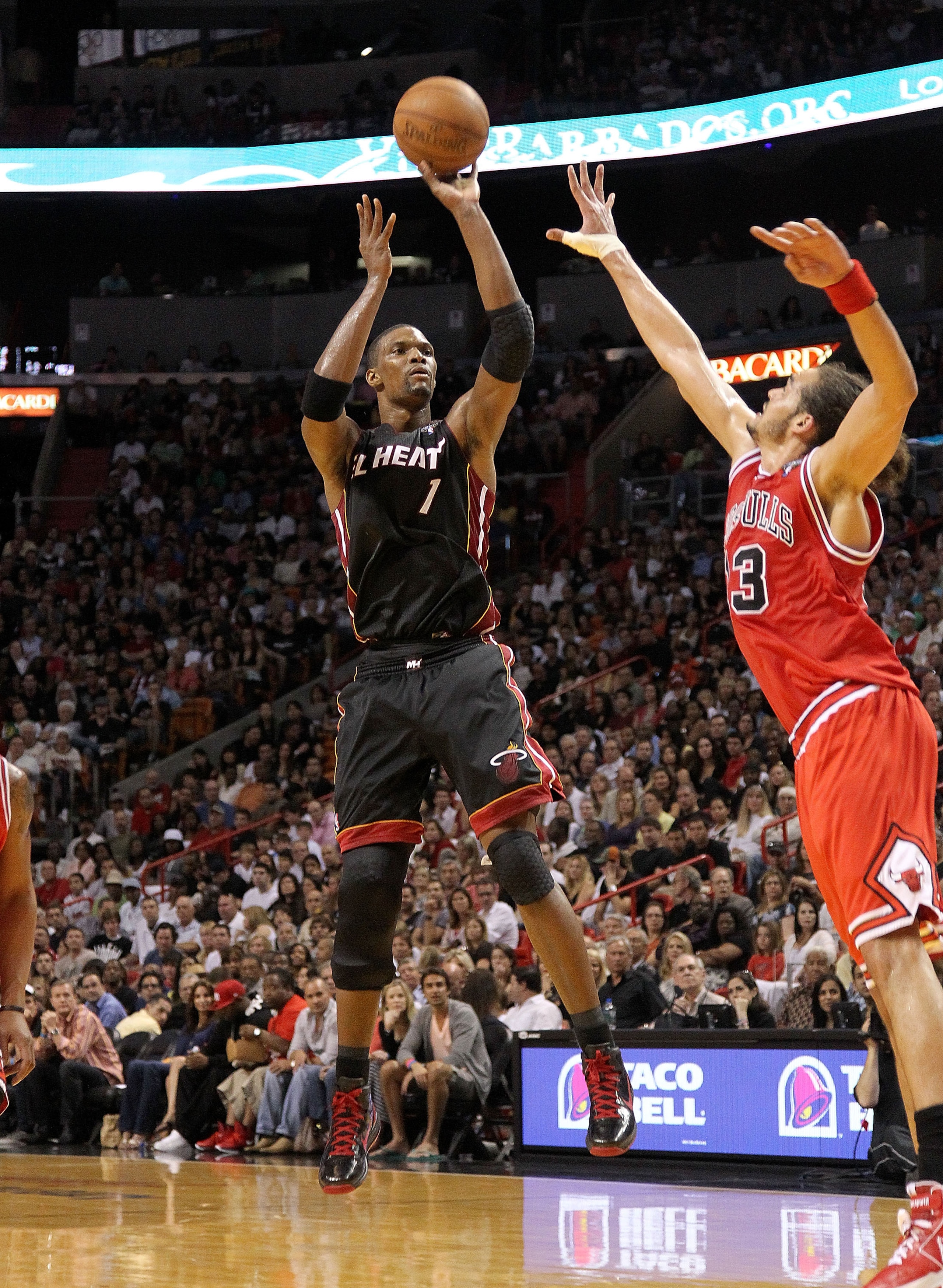 MIAMI, FL - MARCH 06: Chris Bosh #1 of the Miami Heat shoots over Joakim Noah #13 of the Chicago Bulls during a game at American Airlines Arena on March 6, 2011 in Miami, Florida. NOTE TO USER: User expressly acknowledges and agrees that, by downloading a