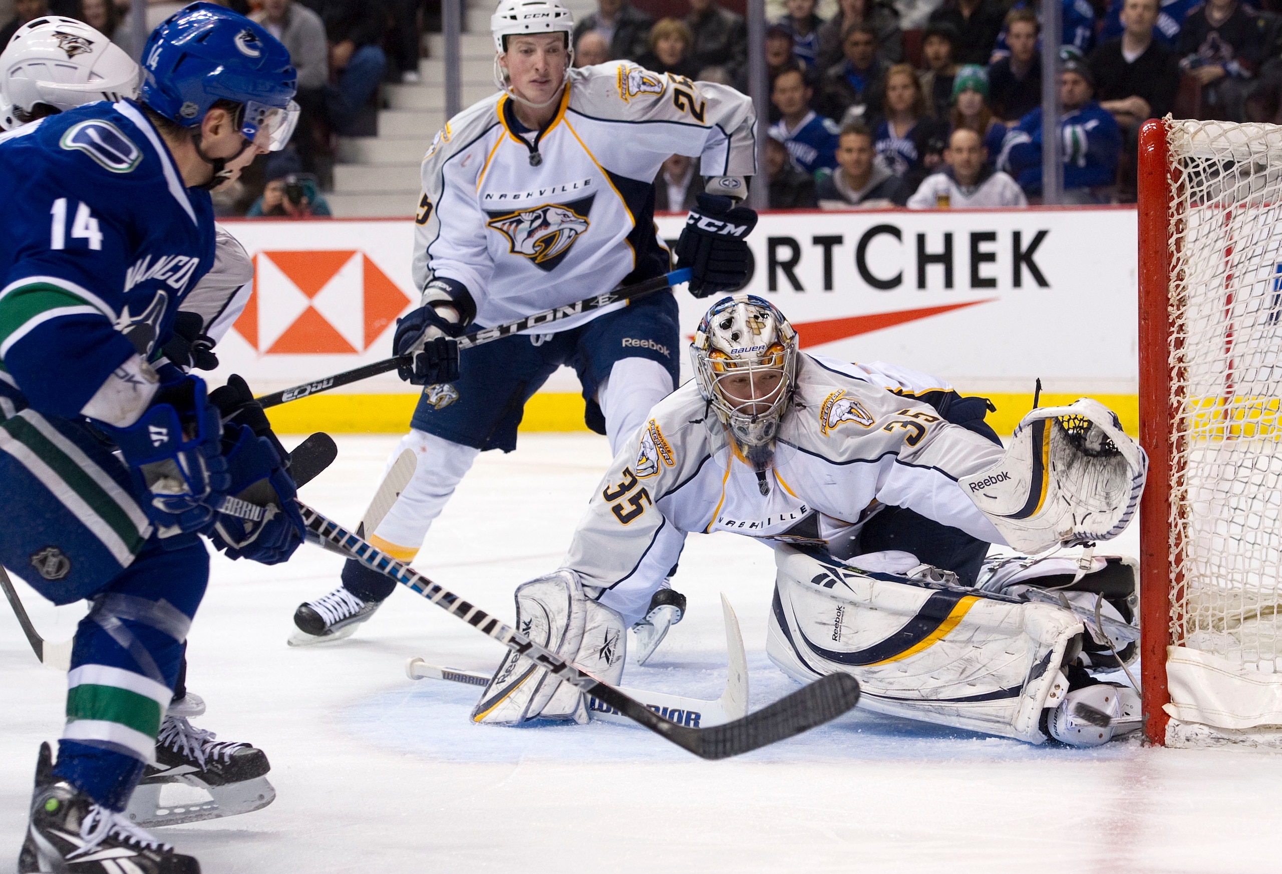 VANCOUVER, CANADA - MARCH 3: Alexandre Burrows #14 of the Vancouver Canucks is stopped in close by goalie Pekka Rinne #35 of the Nashville Predators while Jerred Smithson #25 looks on during the second period in NHL action on March 03, 2011 at Rogers Aren