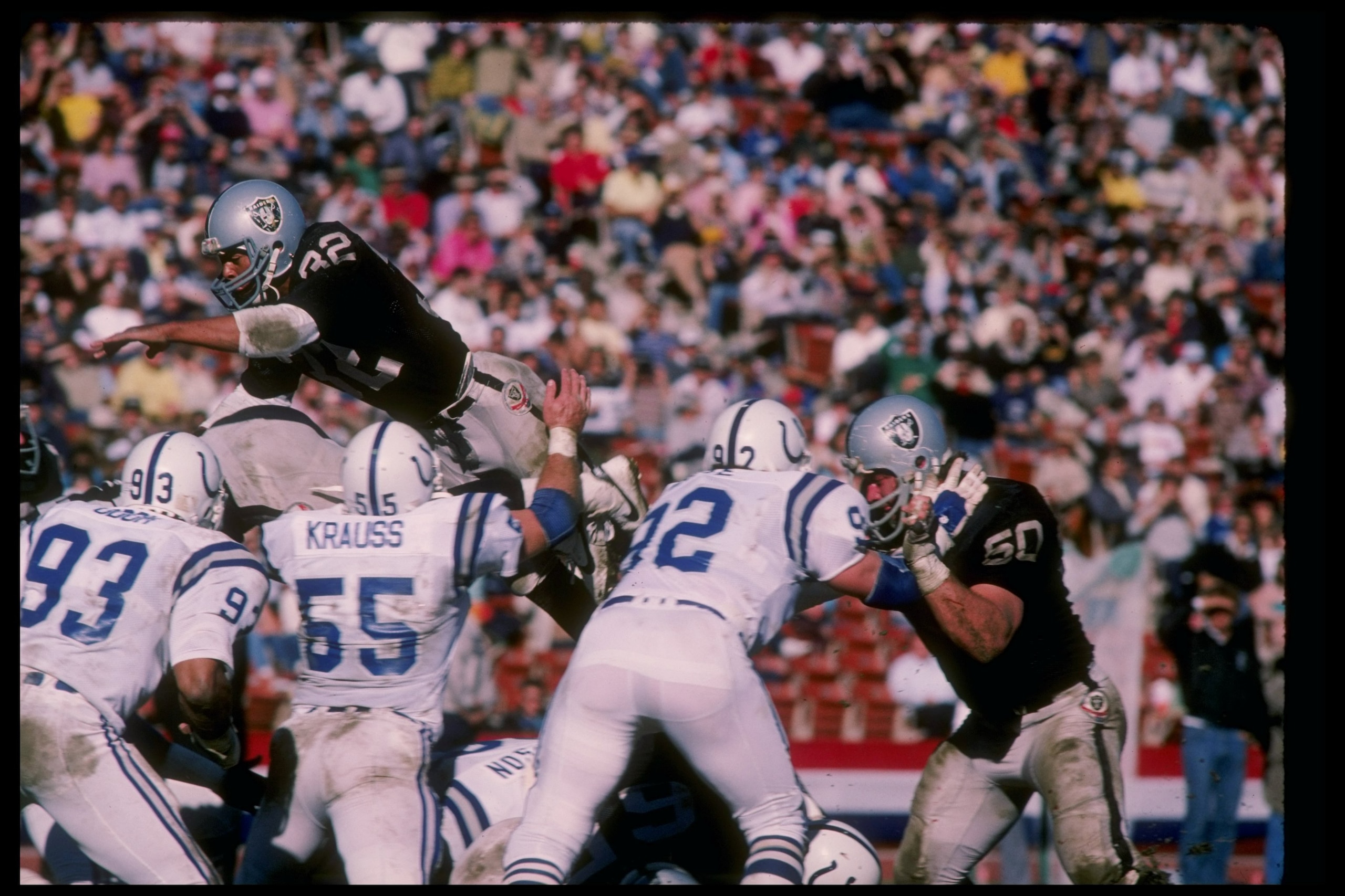 25 Nov 1984:  Running back Marcus Allen of the Los Angeles Raiders (top) sails over for a touchdown during a game against the Indianapolis Colts at the Los Angeles Memorial Coliseum in Los Angeles, California.  The Raiders won the game 21-7. Mandatory Cre