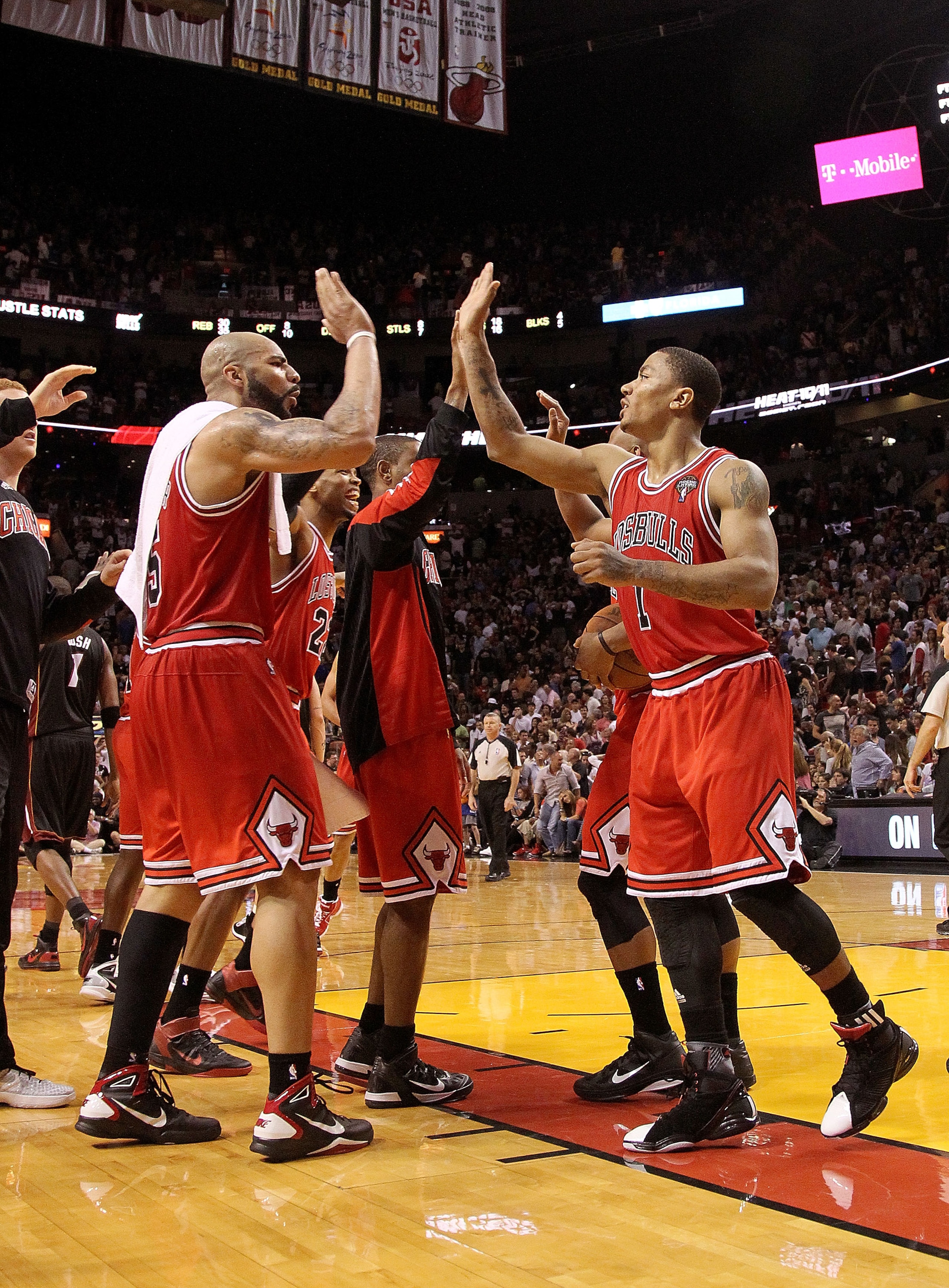 MIAMI, FL - MARCH 06:  Derrick Rose #1 and Carlos Boozer #5 of the Chicago Bulls high five after winning a game against the Miami Heat at American Airlines Arena on March 6, 2011 in Miami, Florida. NOTE TO USER: User expressly acknowledges and agrees that