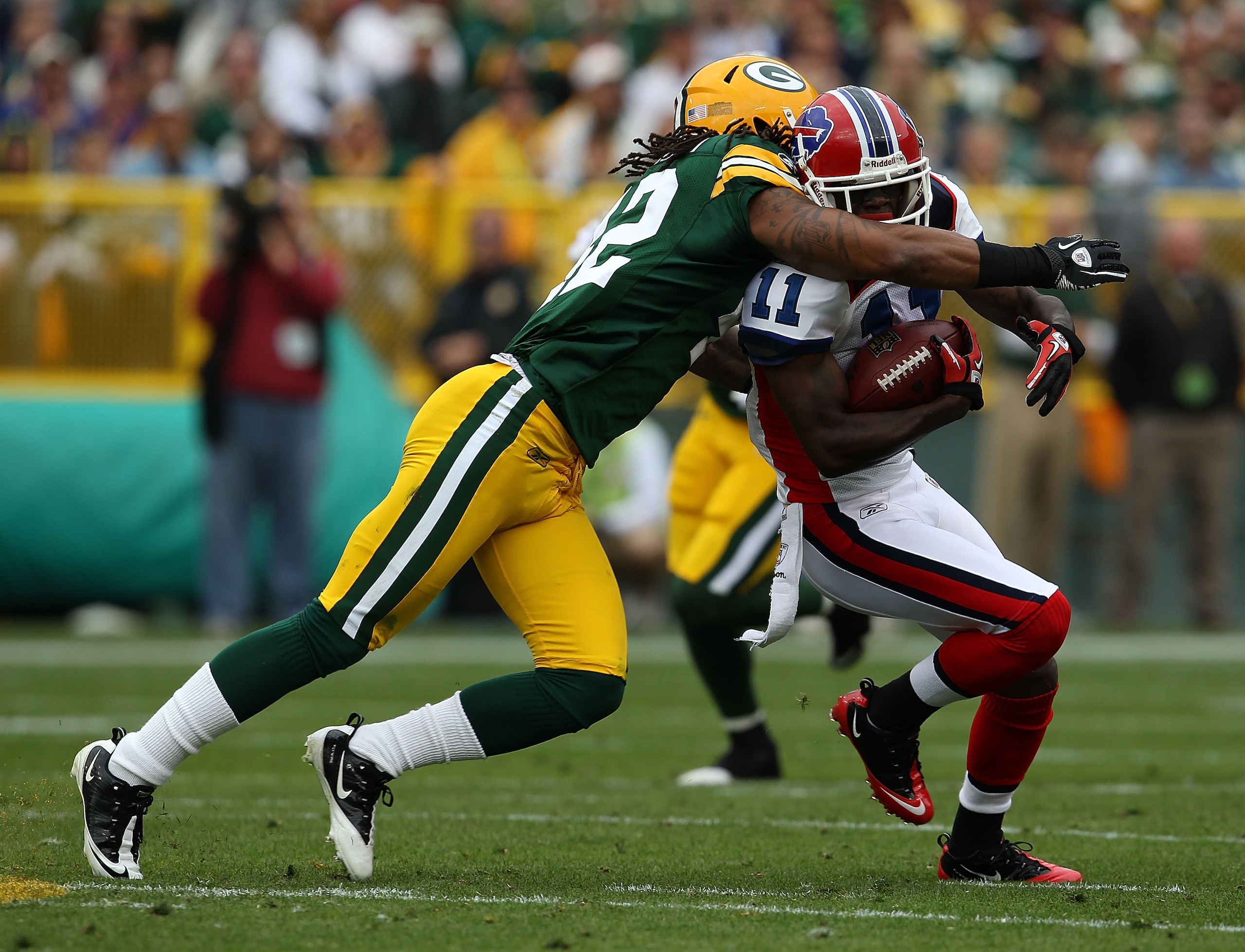 GREEN BAY, WI - SEPTEMBER 19: Roscoe Parrish #11 of the Buffalo Bills is hit by Morgan Burnett #42 of the Green Bay Packers after catching a pass at Lambeau Field on September 19, 2010 in Green Bay, Wisconsin. The Packers defeated the Bills 34-7.  (Photo
