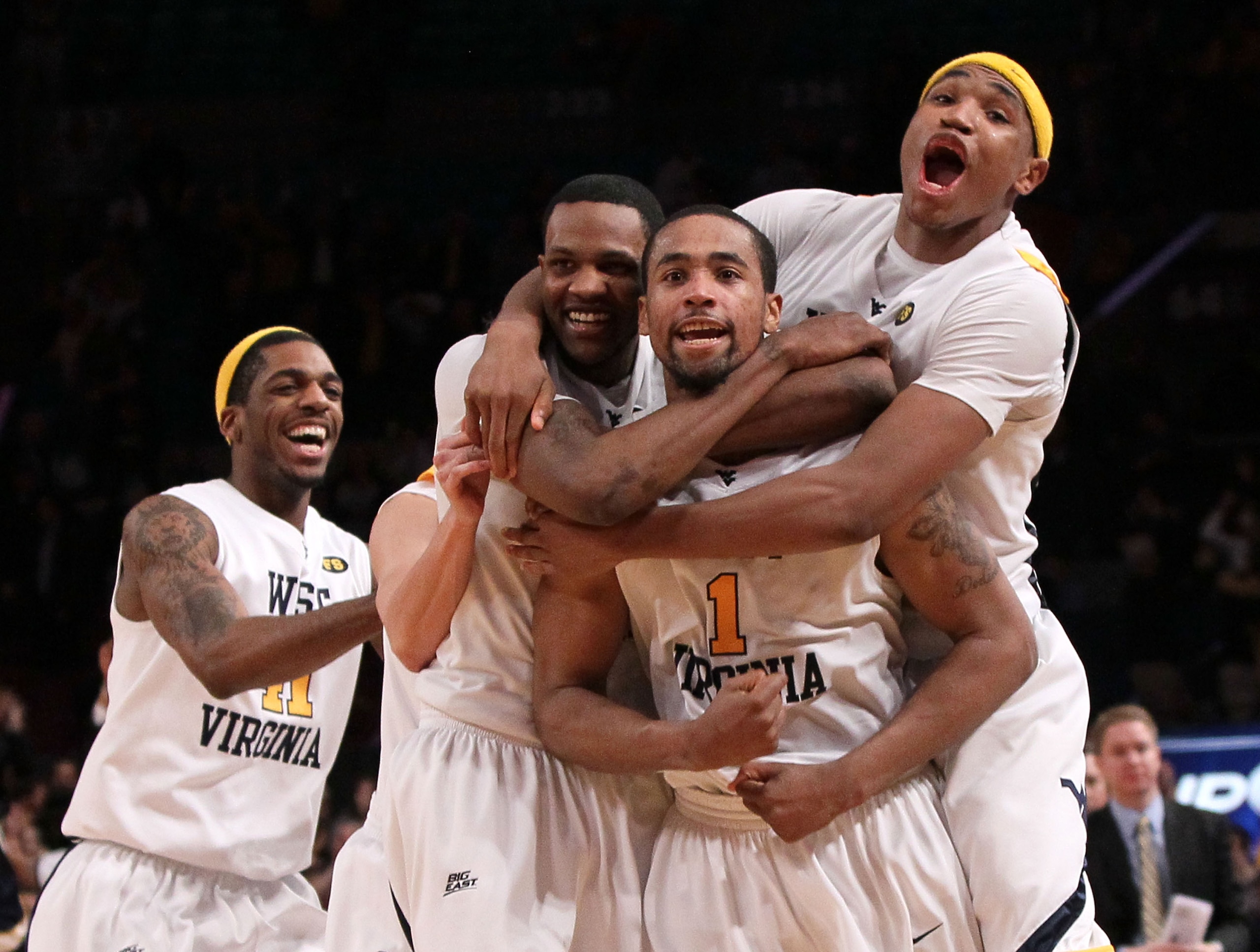 NEW YORK - MARCH 11: Da'Sean Butler #1 of the West Virginia Mountaineers celebrates with teammates John Flowers #41, Devin Ebanks #3 and Kevin Jones #5 after making a game winning three pointer to defeat the Cincinnati Bearcats during the quarterfinal of