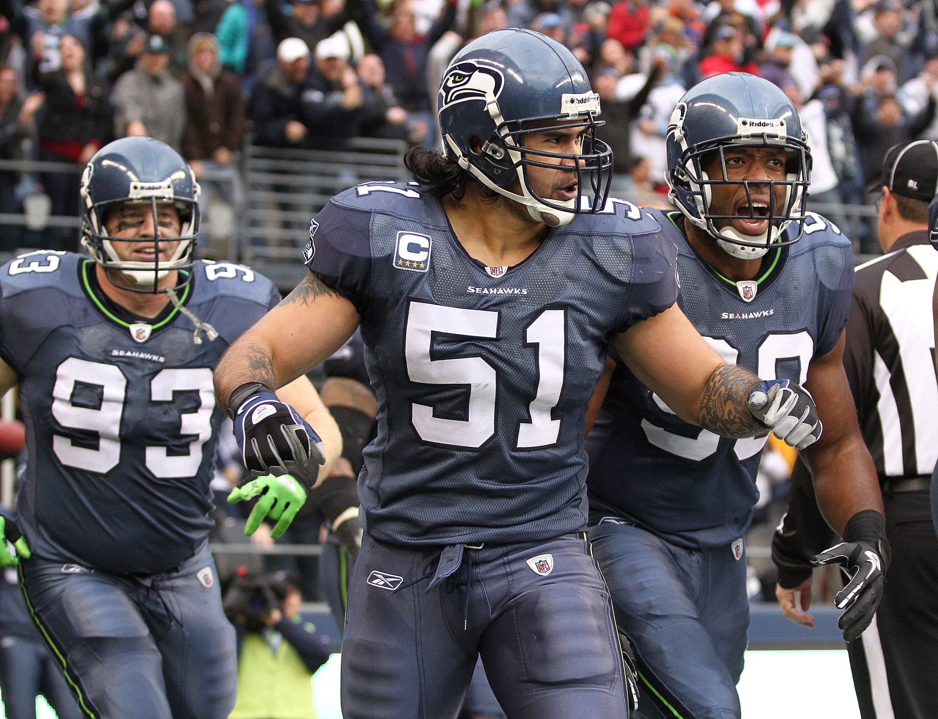 SEATTLE, WA - DECEMBER 05:  Linebacker Lofa Tatupu #51 of the Seattle Seahawks celebrates with Jay Richardson #99 and Craig Terrill #93 after returning an interception for a touchdown against the Carolina Panthers at Qwest Field on December 5, 2010 in Sea