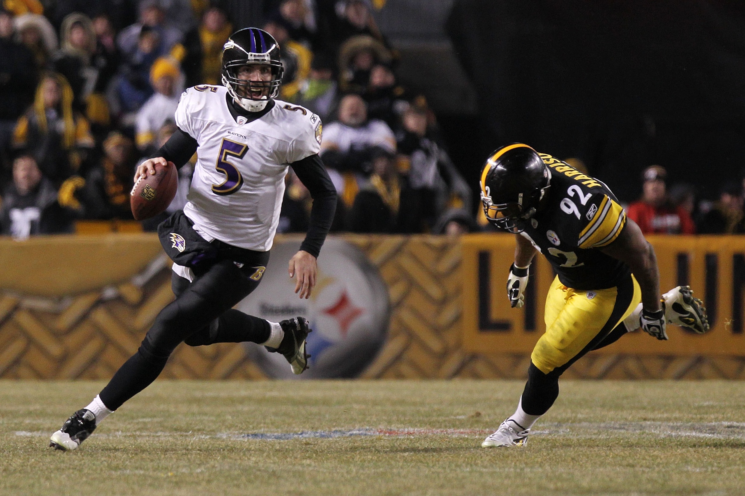 PITTSBURGH, PA - JANUARY 15:  Quarterback Joe Flacco #5 of the Baltimore Ravens runs with the ball as linebacker James Harrison #92 of the Pittsburgh Steelers chases him in the AFC Divisional Playoff Game at Heinz Field on January 15, 2011 in Pittsburgh,