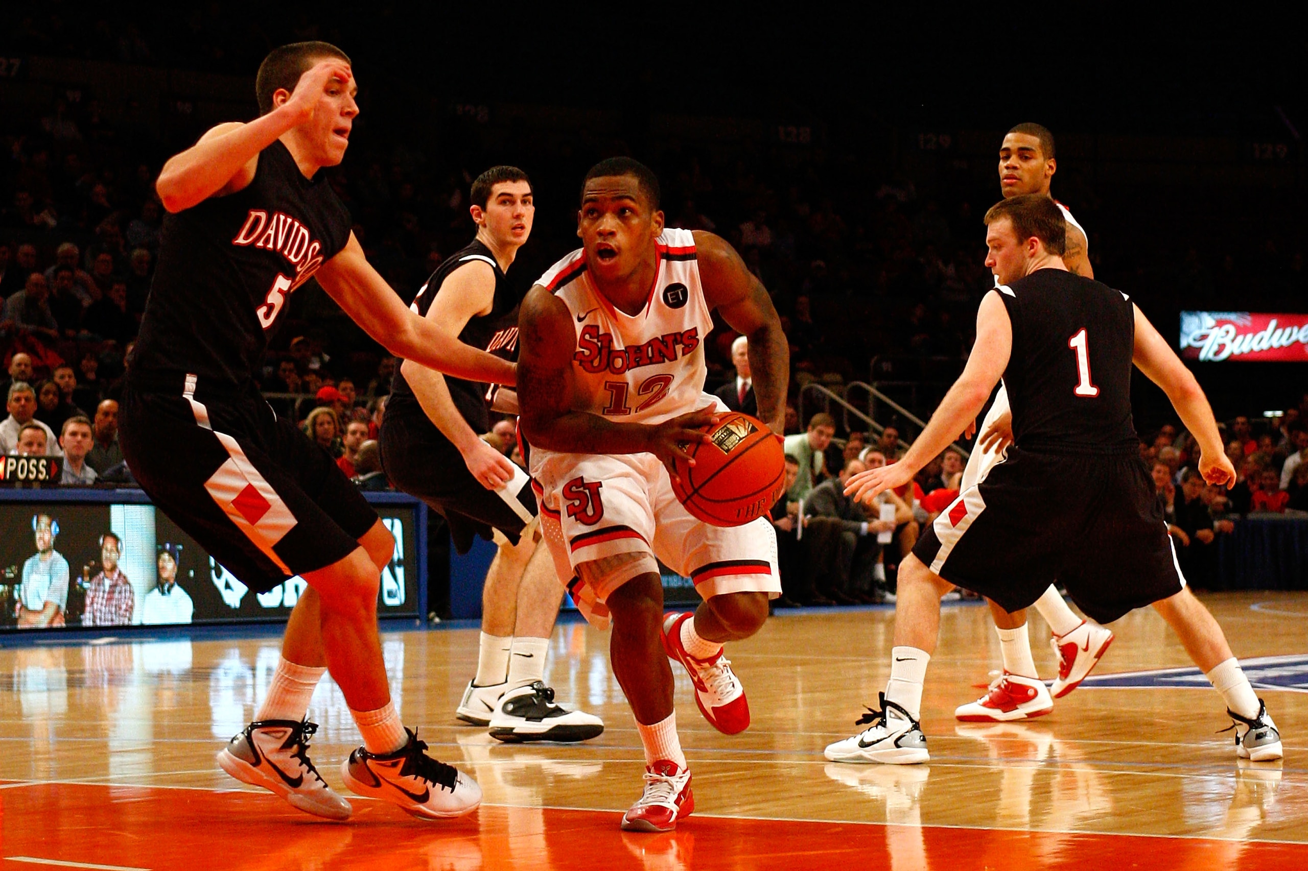 NEW YORK, NY - DECEMBER 20:  Dwight Hardy #12 of the St. John's Red Storm drives against JP Kuhlman #5 and Brendan McKillop #1 of the Davidson Wildcats during the Madison Square Garden Holiday Festival at Madison Square Garden on December 20, 2010 in New