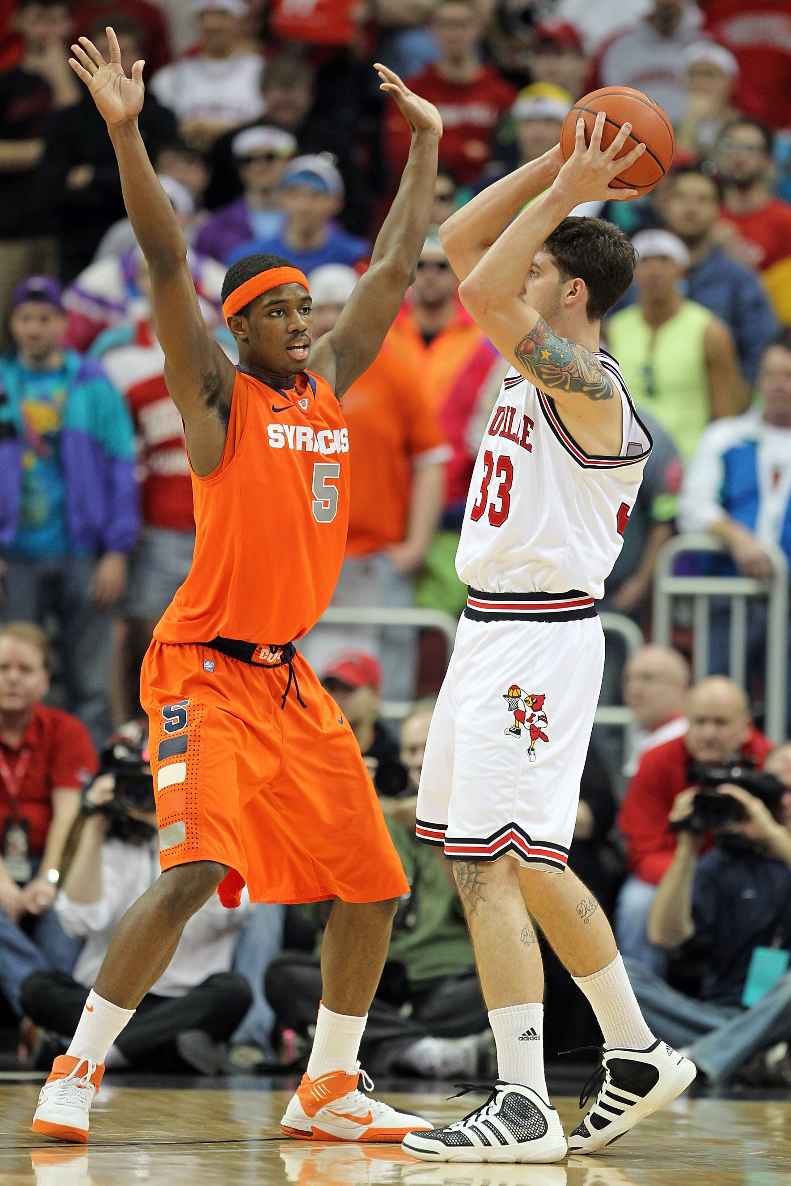 LOUISVILLE, KY - FEBRUARY 12: C.J. Fair #5 of the Syracuse Orange defends Mike Marra #33 of the Louisville Cardinals during the Big East Conference game at the KFC Yum! Center on February 12, 2011 in Louisville, Kentucky.  Louisville won 73-69.  (Photo by