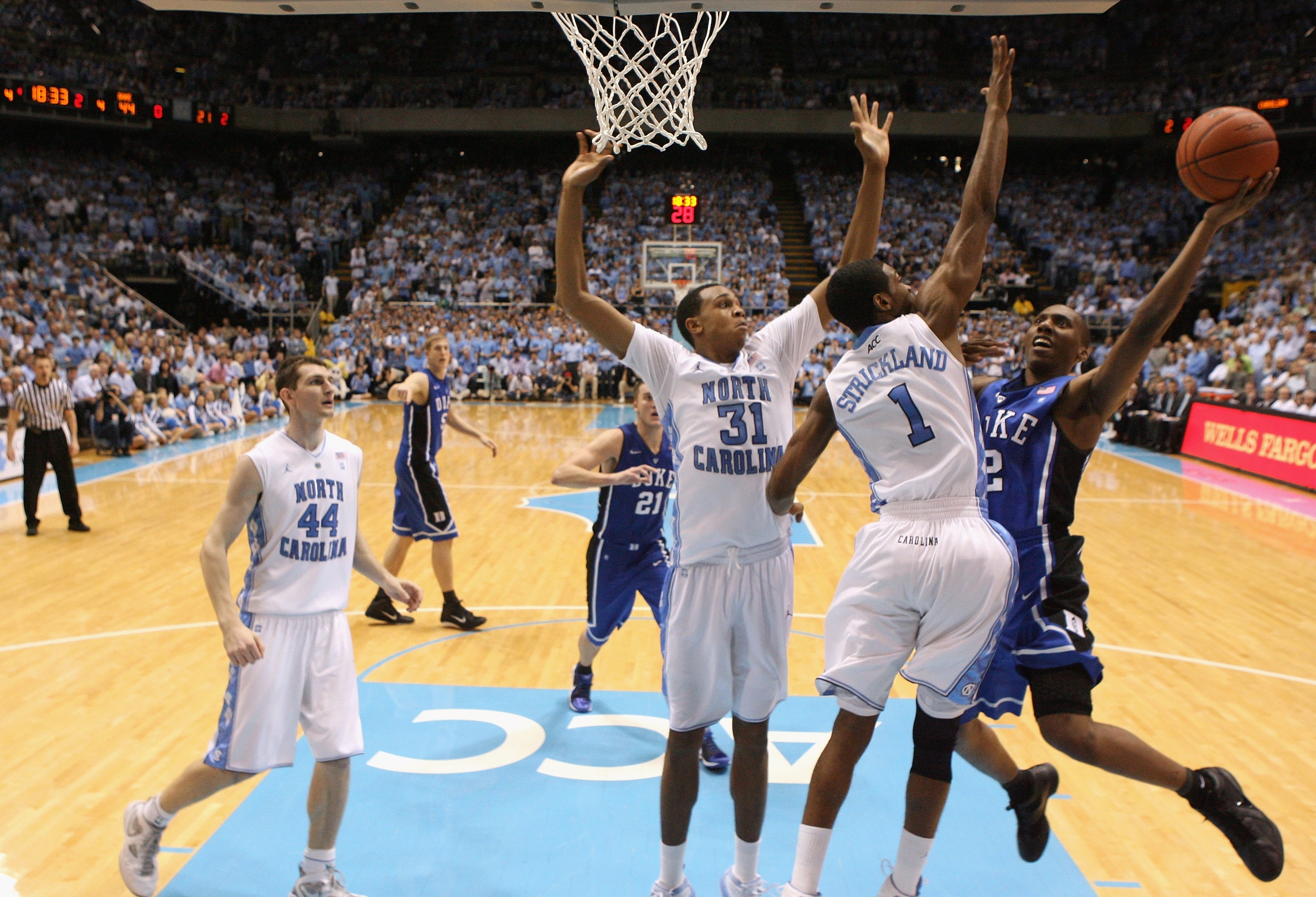 CHAPEL HILL, NC - MARCH 05:  Nolan Smith #2 of the Duke Blue Devils drives to the basket on teammates John Henson #31 and Dexter Stickland #1 of the North Carolina Tar Heels during their game at the Dean E. Smith Center on March 5, 2011 in Chapel Hill, No
