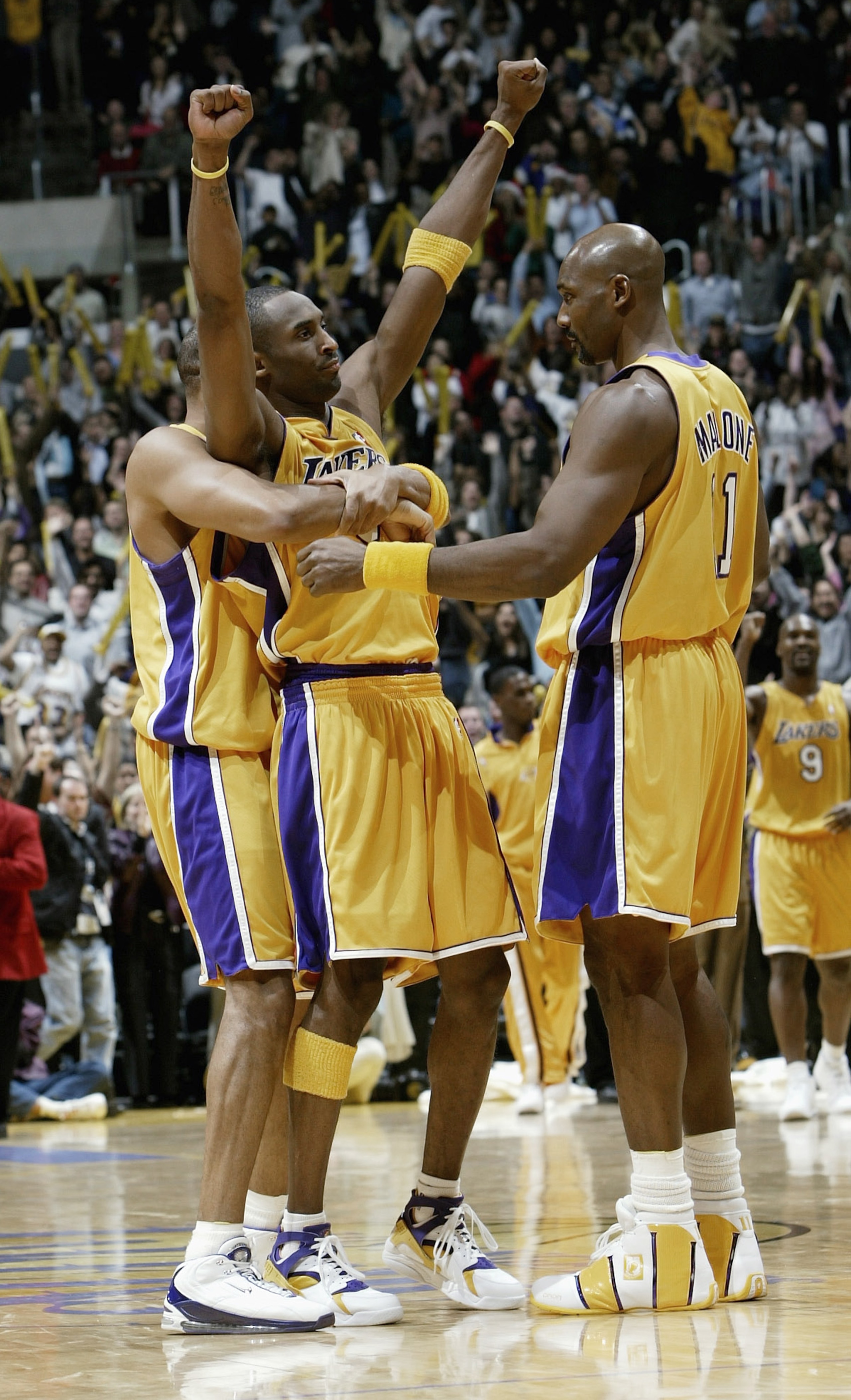 LOS ANGELES - DECEMBER 19: Kobe Bryant #8 of the Los Angeles Lakers celebrates with Devean George #3 and Karl Malone #11 after hitting the winning shot at the buzzer in the game against the Denver Nuggets on December 19, 2003 at Staples Center in Los Ange LOS ANGELES - DECEMBER 19: Kobe Bryant #8 of the Los Angeles Lakers celebrates with Devean George #3 and Karl Malone #11 after hitting the winning shot at the buzzer in the game against the Denver Nuggets on December 19, 2003 at Staples Center in Los Ange